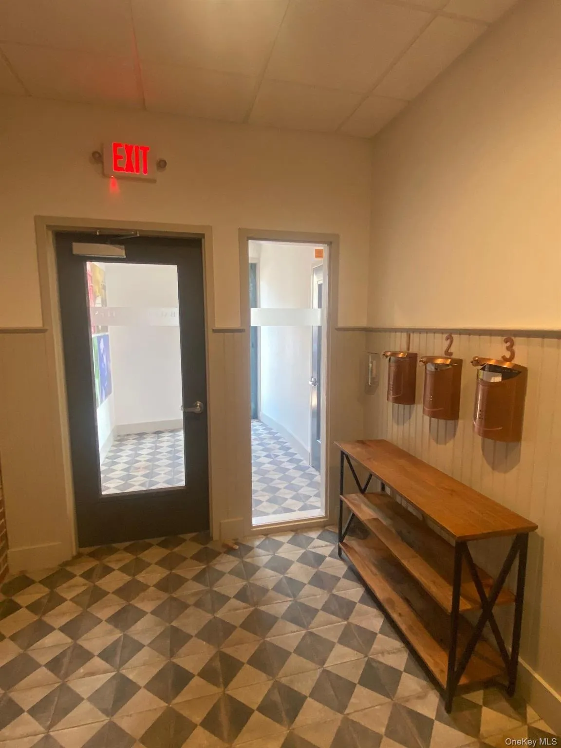 Entrance foyer featuring dark floors, wainscoting, and a paneled ceiling Entrance foyer featuring dark floors, wainscoting, and a paneled ceiling