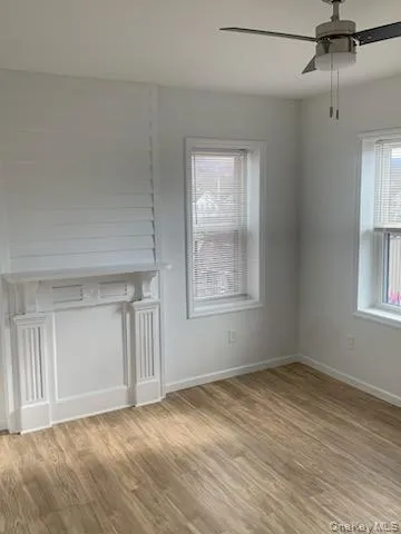 Unfurnished living room with wood finished floors and ceiling fan Unfurnished living room with wood finished floors and ceiling fan