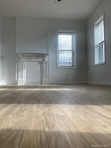 Unfurnished living room featuring wood finished floors and ceiling fan Unfurnished living room featuring wood finished floors and ceiling fan