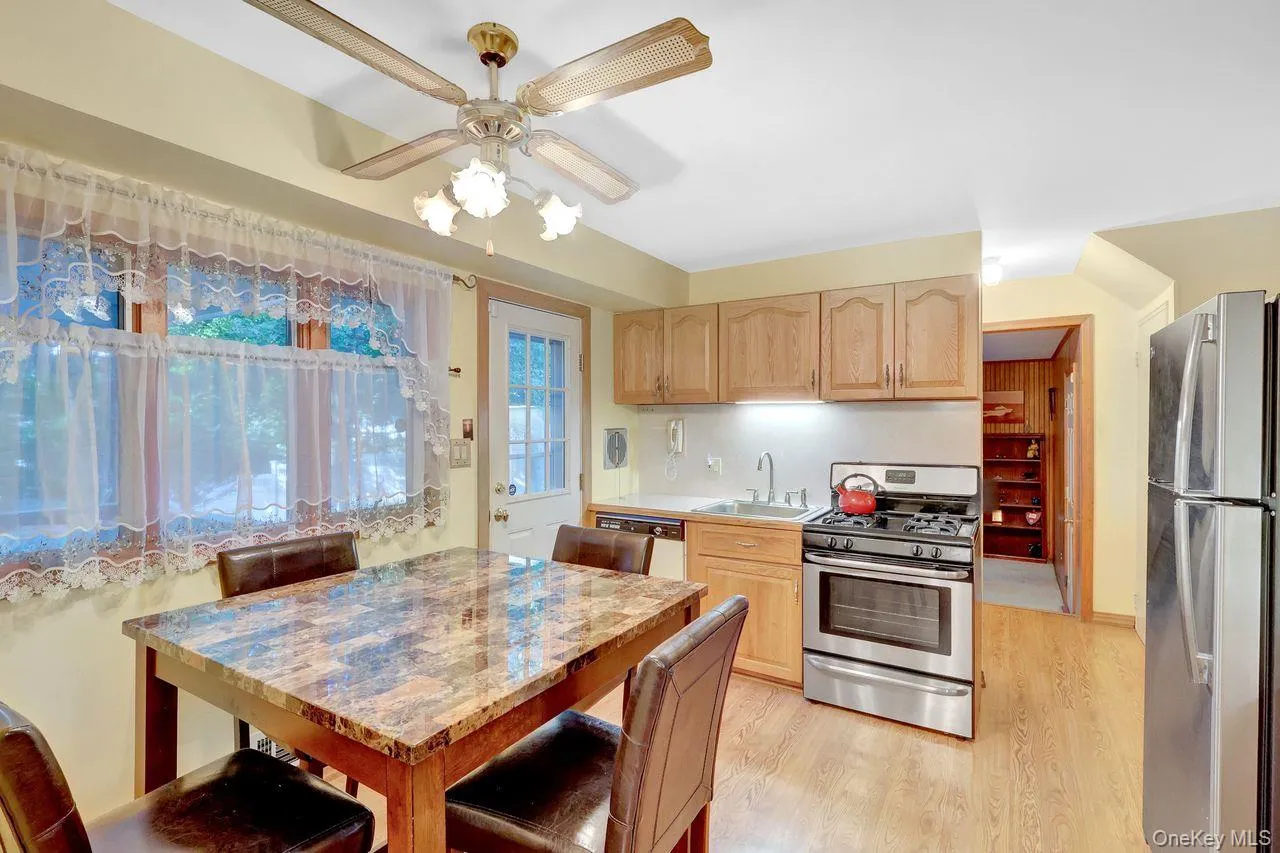 Natural wood-finish flooring, light-toned cabinetry, stainless steel range, and stainless steel refrigerator Natural wood-finish flooring, light-toned cabinetry, stainless steel range, and stainless steel refrigerator