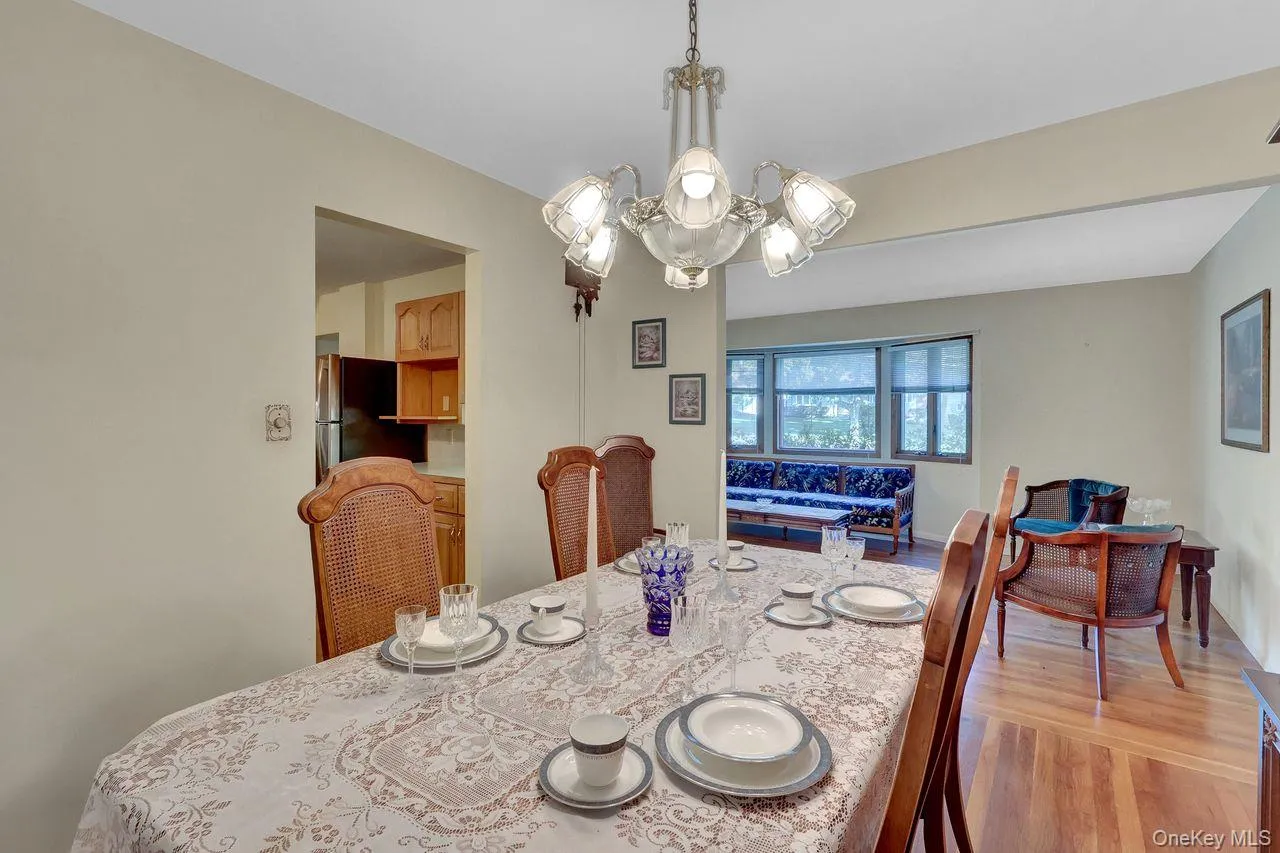 Wood-finish flooring, and a decorative chandelier illuminate the space Wood-finish flooring, and a decorative chandelier illuminate the space
