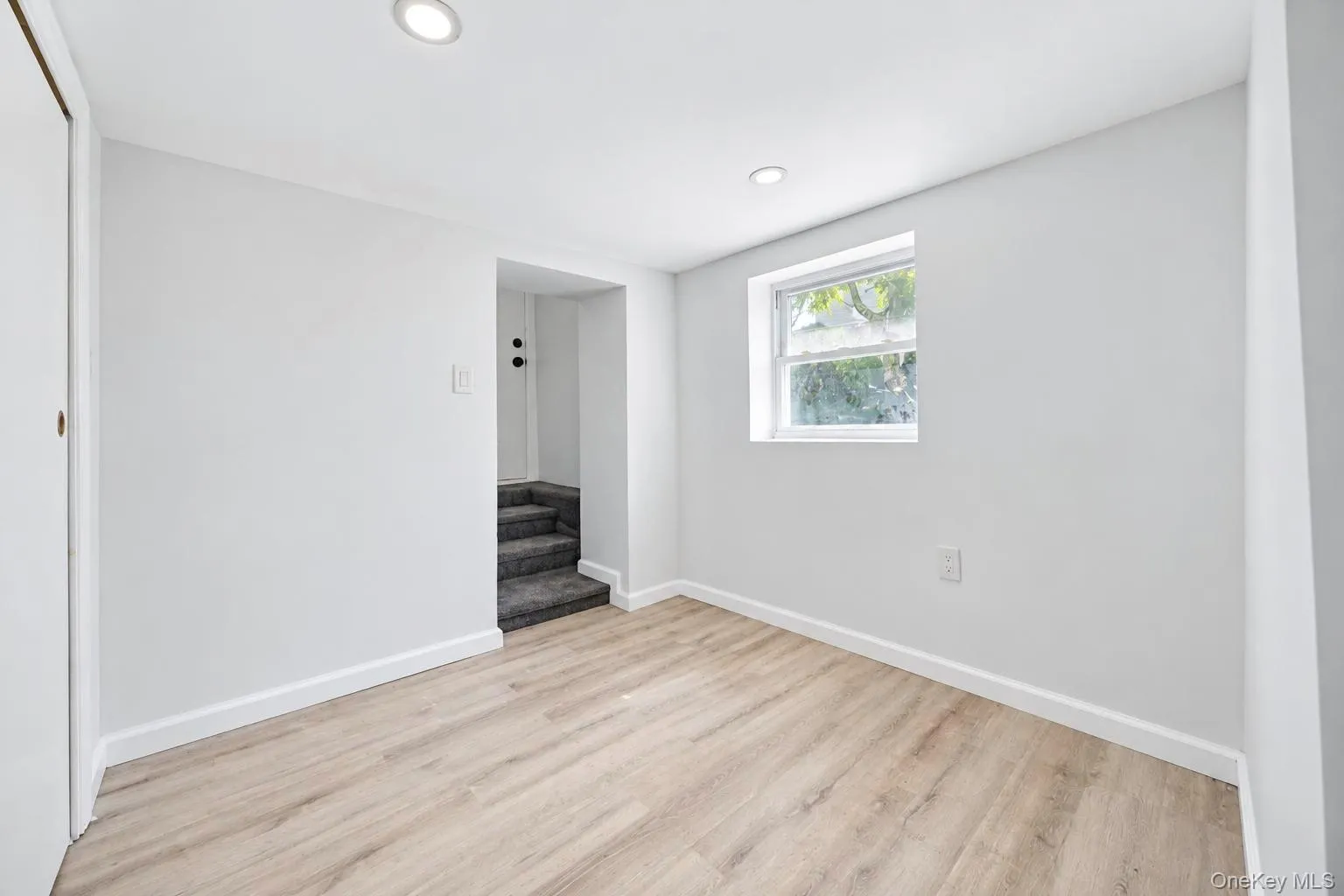 Recessed ceiling lighting, wood-finish flooring, white painted walls, white trim, and a double-hung window Recessed ceiling lighting, wood-finish flooring, white painted walls, white trim, and a double-hung window