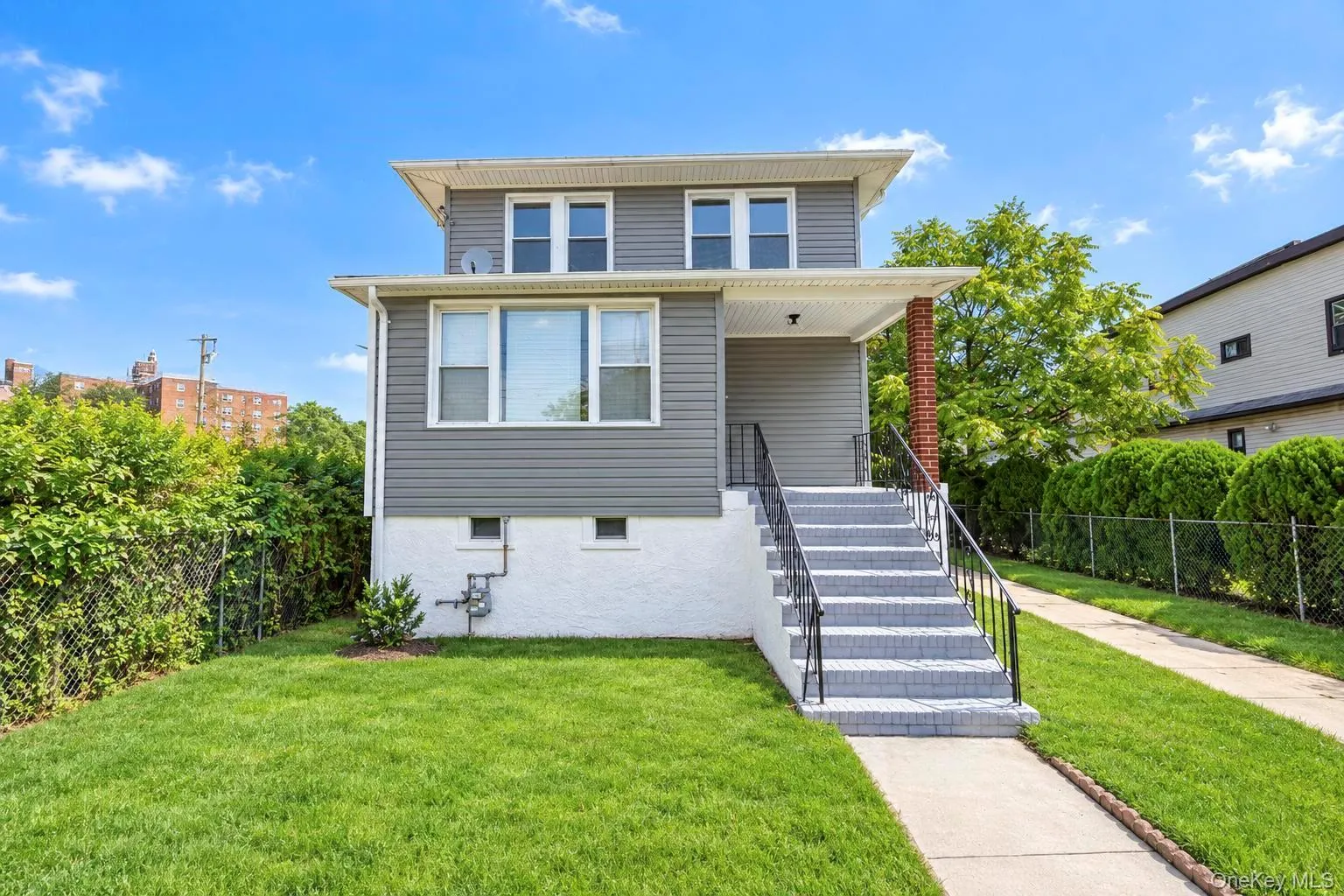 Two-story residence featuring grey siding and white trim Two-story residence featuring grey siding and white trim