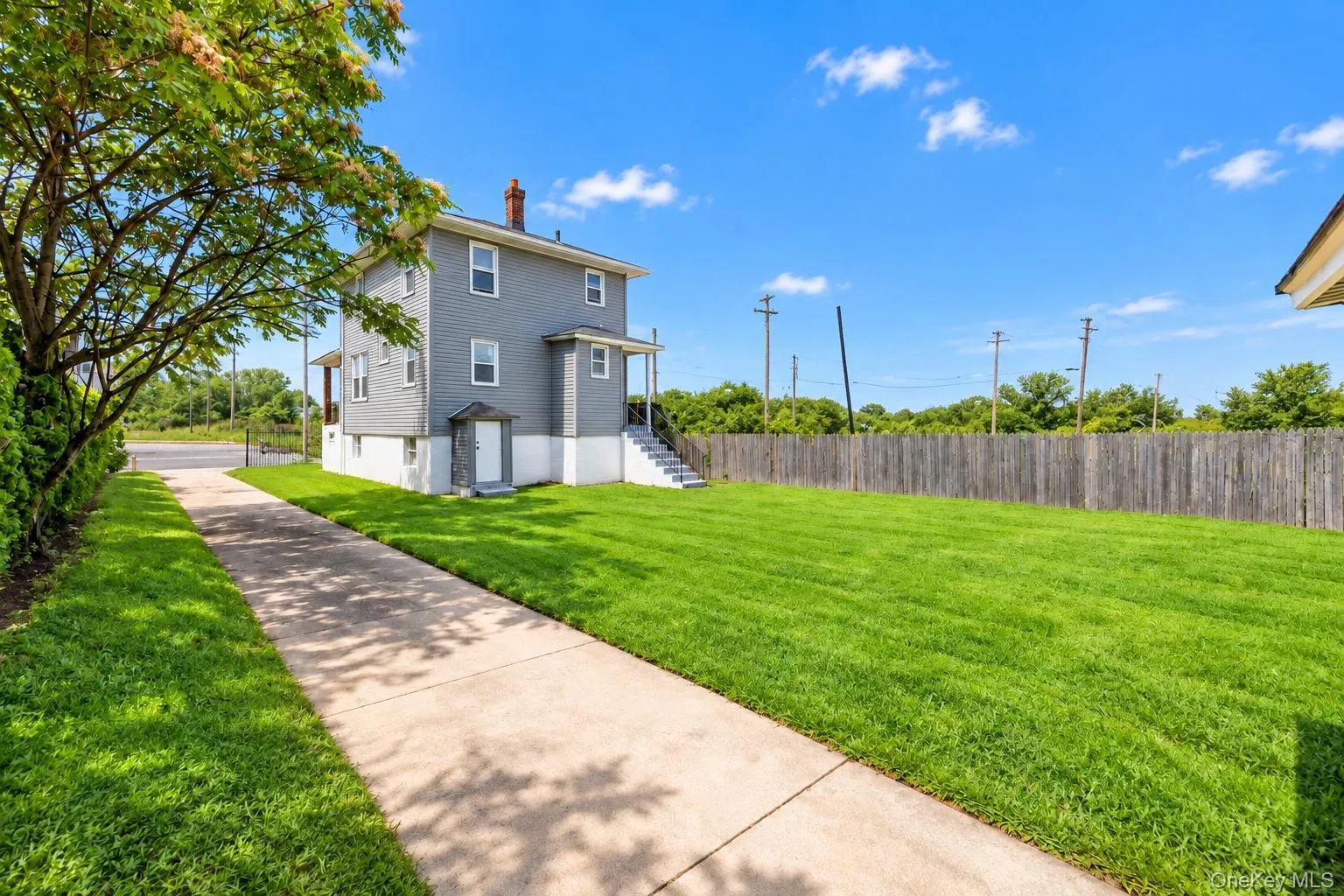 Two-story exterior with gray siding, white trim, and a concrete driveway Two-story exterior with gray siding, white trim, and a concrete driveway