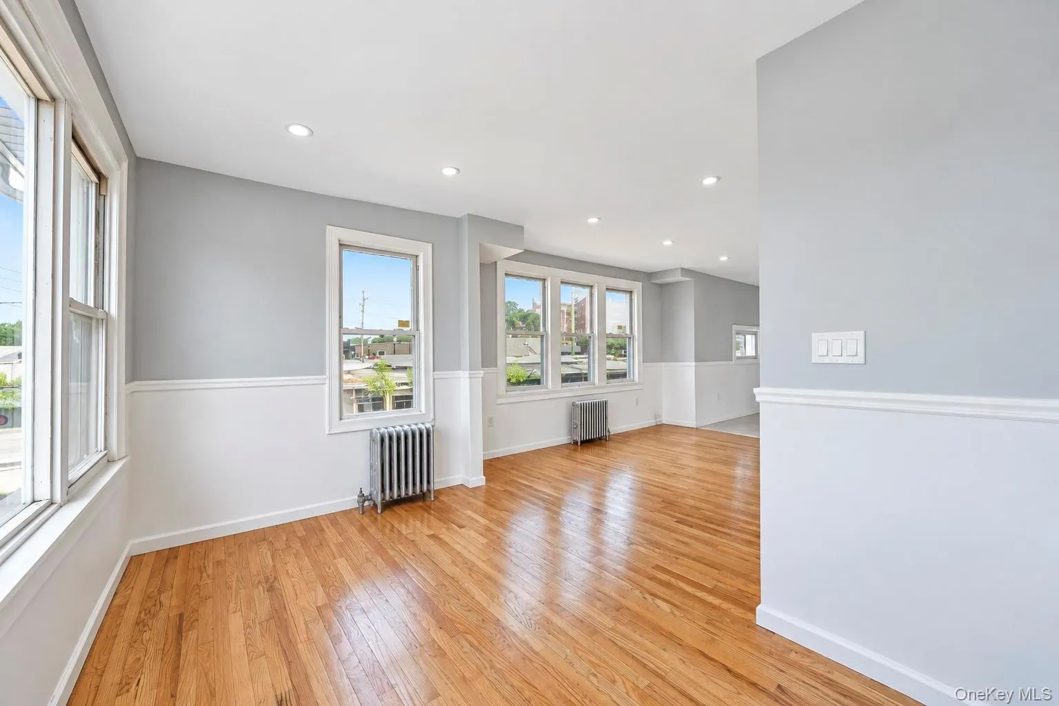 Hardwood flooring, recessed lighting, multiple windows, two-tone wall treatment, and baseboard molding Hardwood flooring, recessed lighting, multiple windows, two-tone wall treatment, and baseboard molding