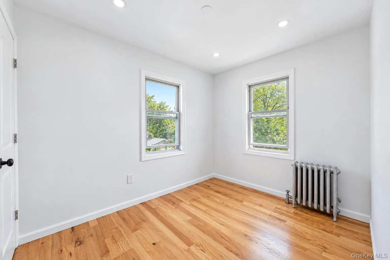 Hardwood flooring, recessed ceiling lighting, and two windows Hardwood flooring, recessed ceiling lighting, and two windows