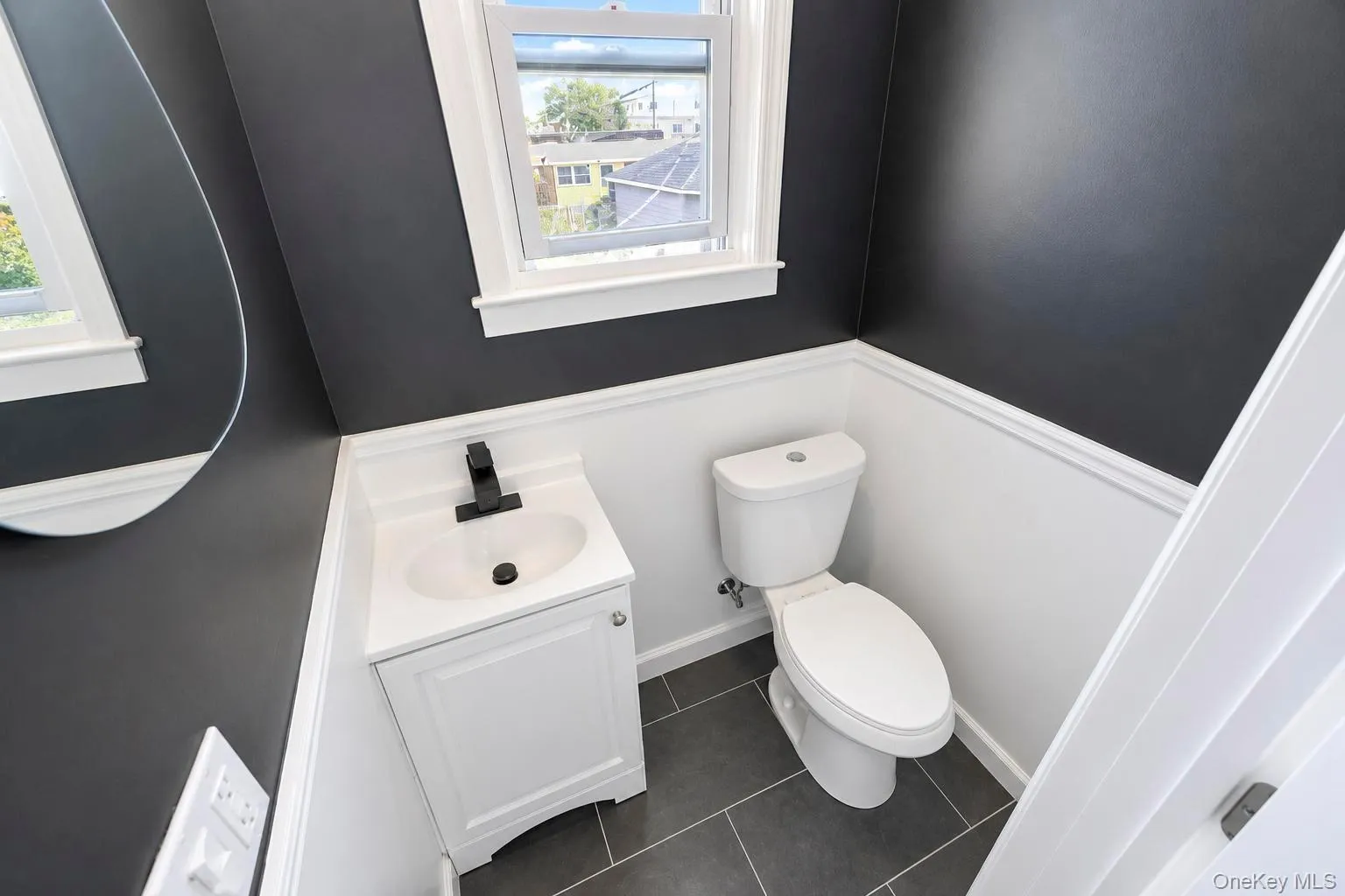 White vanity with a single basin sink and matte black faucet White vanity with a single basin sink and matte black faucet