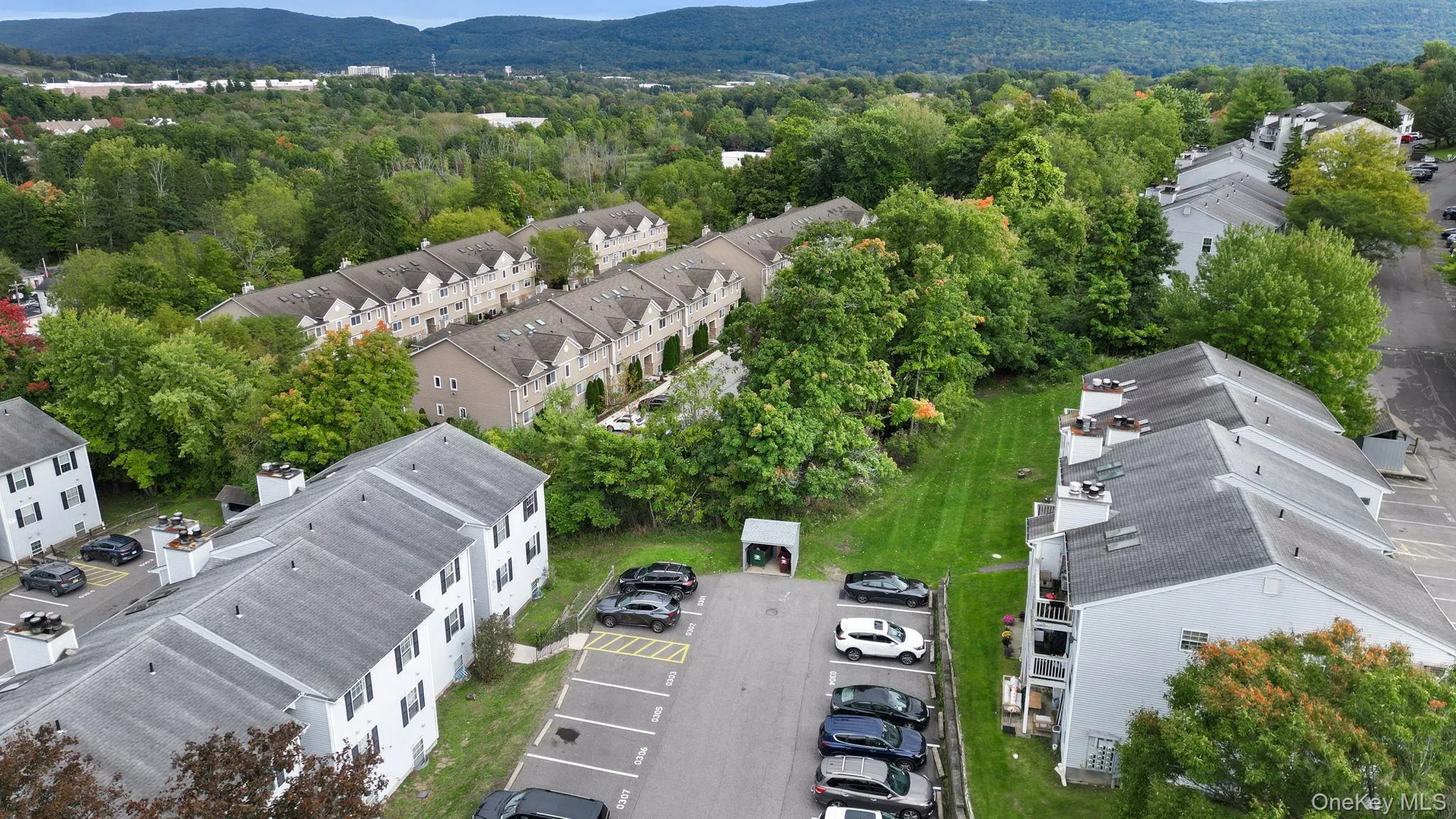 Aerial perspective of multiple buildings with pitched roofs, balconies, and surrounding green spaces Aerial perspective of multiple buildings with pitched roofs, balconies, and surrounding green spaces