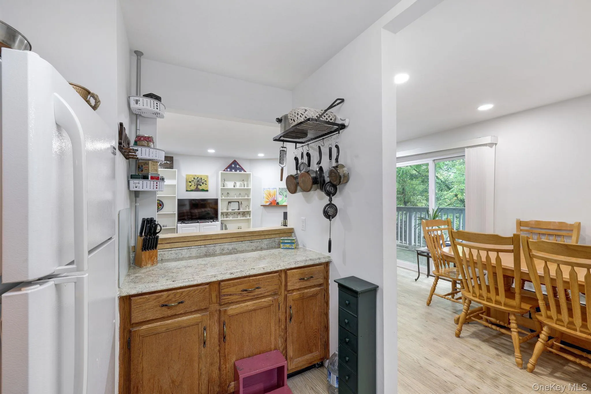 Kitchen pass-through with wood-finish cabinetry and light-toned countertop Kitchen pass-through with wood-finish cabinetry and light-toned countertop