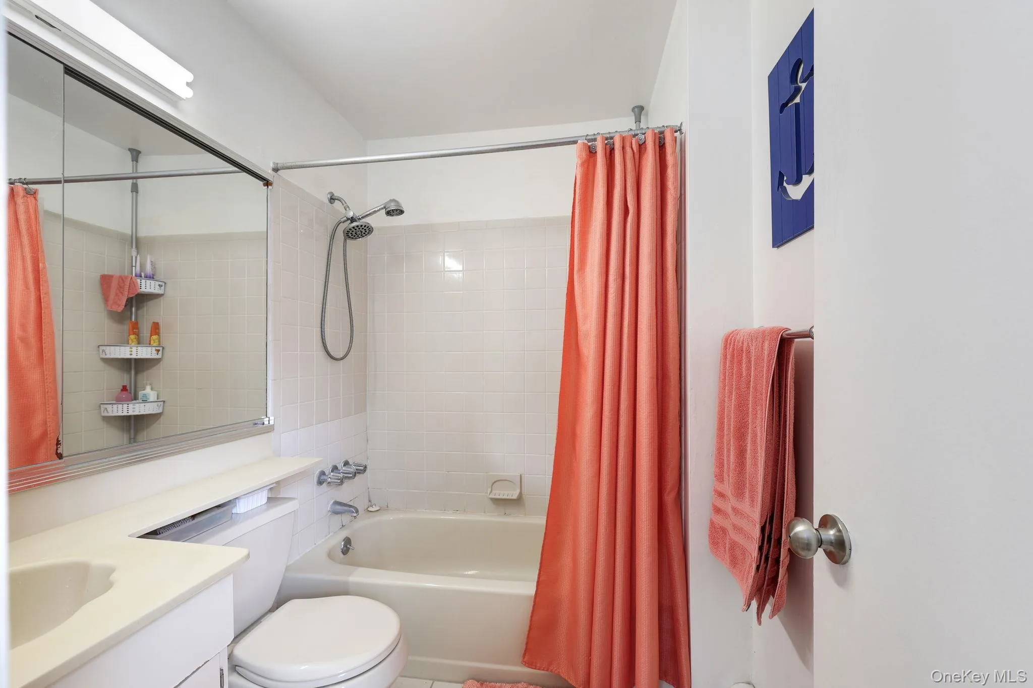 Bathroom featuring a built-in vanity with integrated sink, toilet, and a combination shower and bathtub Bathroom featuring a built-in vanity with integrated sink, toilet, and a combination shower and bathtub