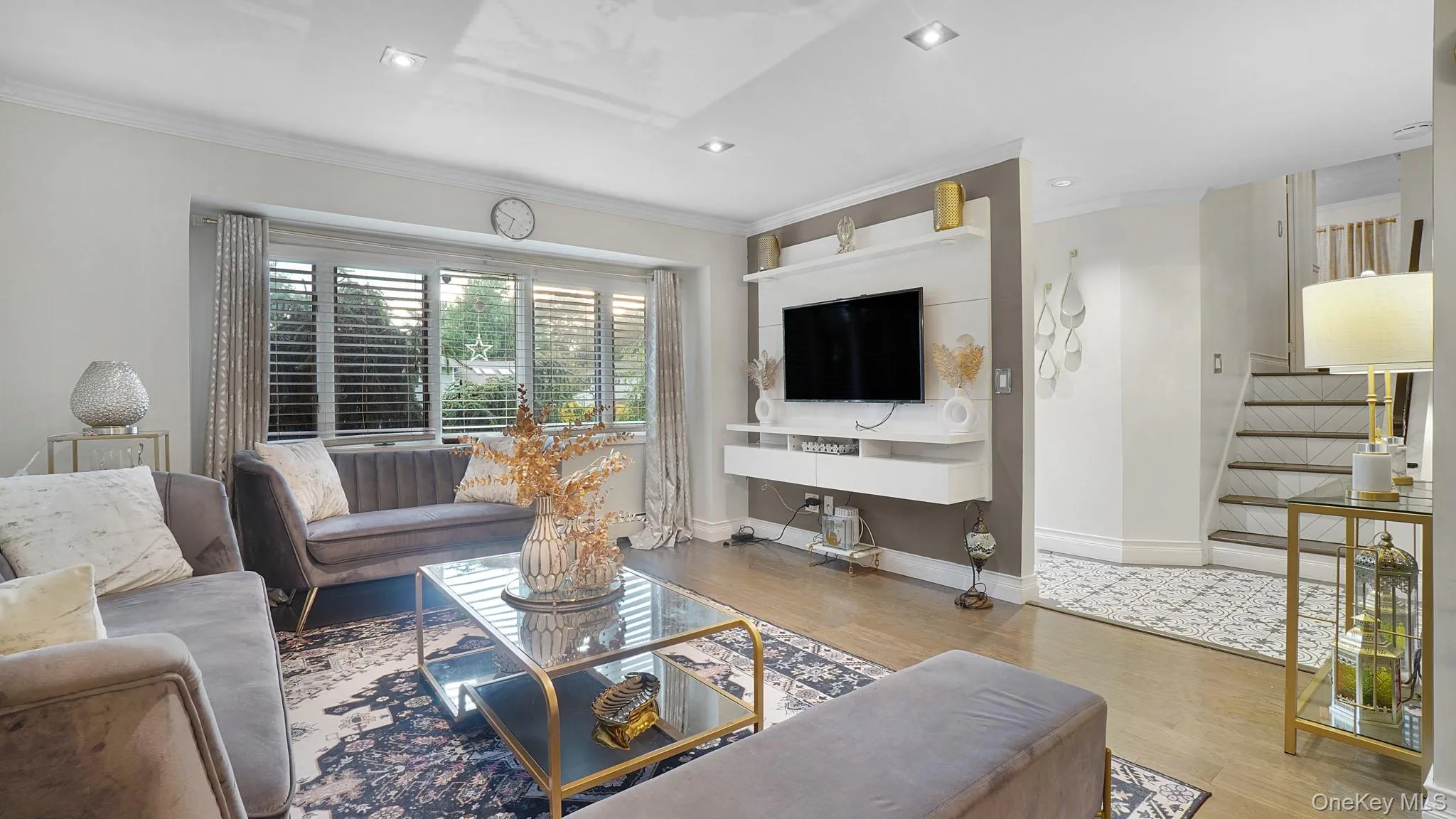 Living area with wood finished floors, ornamental molding, stairway, and recessed lighting Living area with wood finished floors, ornamental molding, stairway, and recessed lighting
