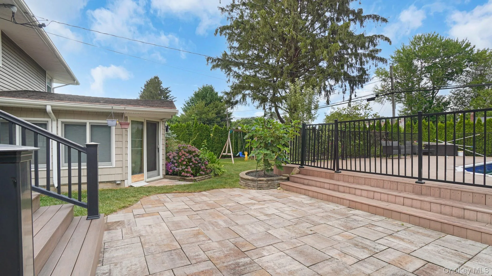Fenced backyard with a patio area and a playground Fenced backyard with a patio area and a playground