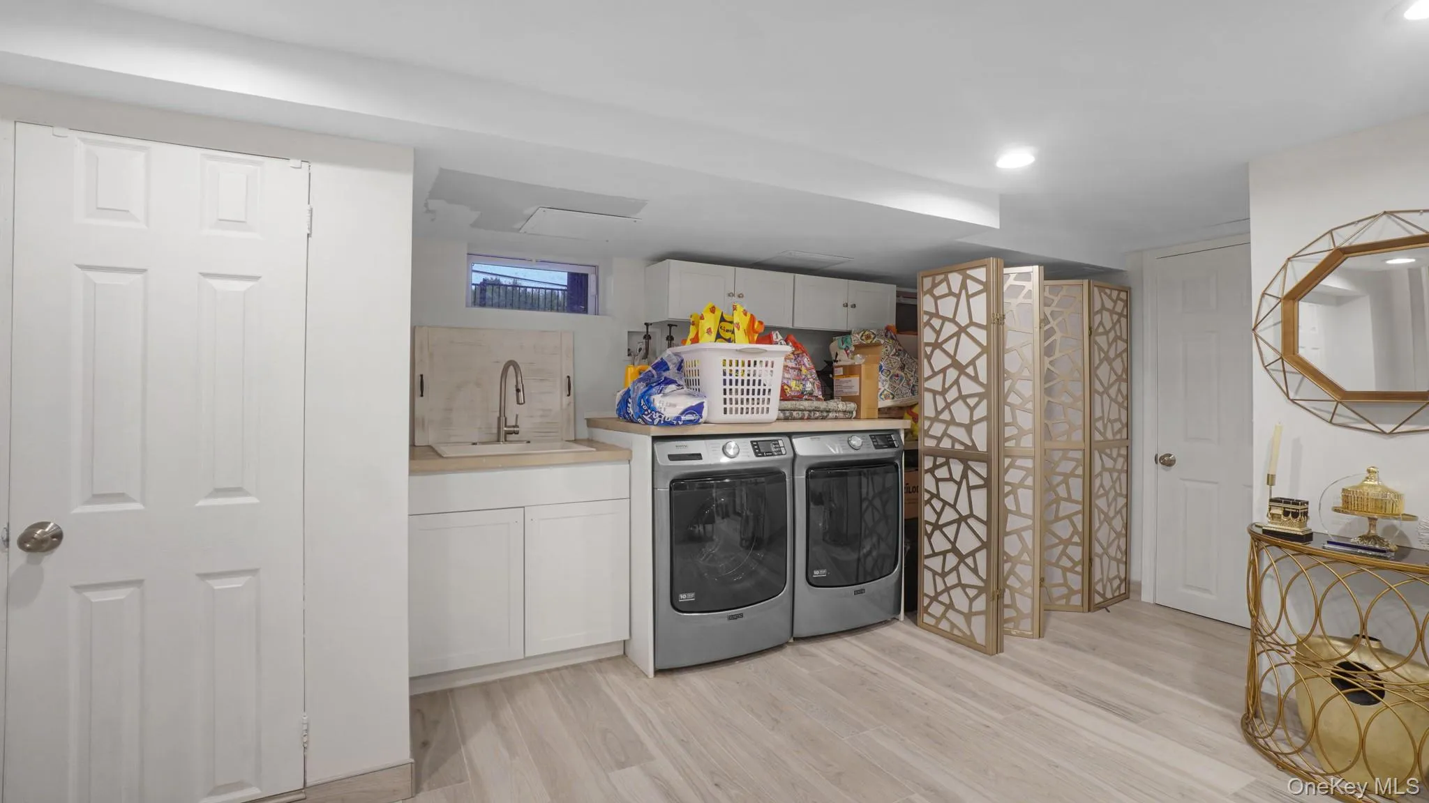 Washroom featuring washer and clothes dryer, light wood-type flooring, and recessed lighting Washroom featuring washer and clothes dryer, light wood-type flooring, and recessed lighting