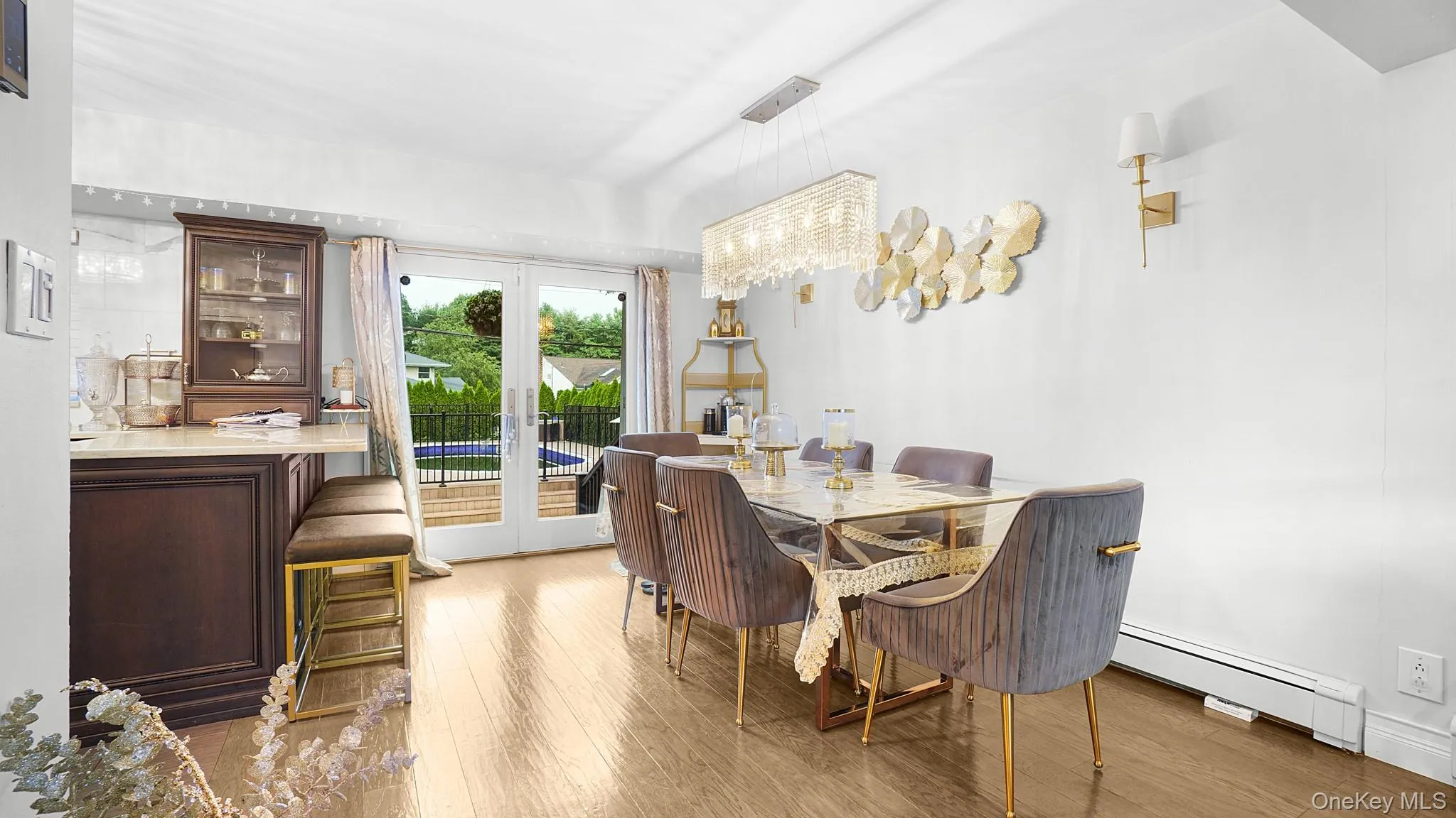 Dining area featuring a baseboard heating unit, wood finished floors, and french doors Dining area featuring a baseboard heating unit, wood finished floors, and french doors