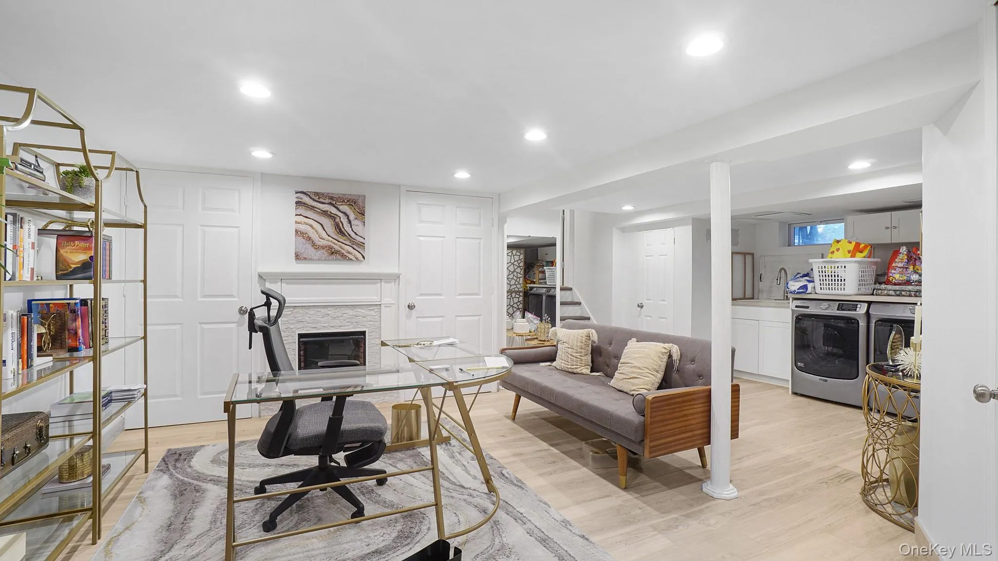 Office featuring washer and dryer, recessed lighting, light wood finished floors, and a glass covered fireplace Office featuring washer and dryer, recessed lighting, light wood finished floors, and a glass covered fireplace