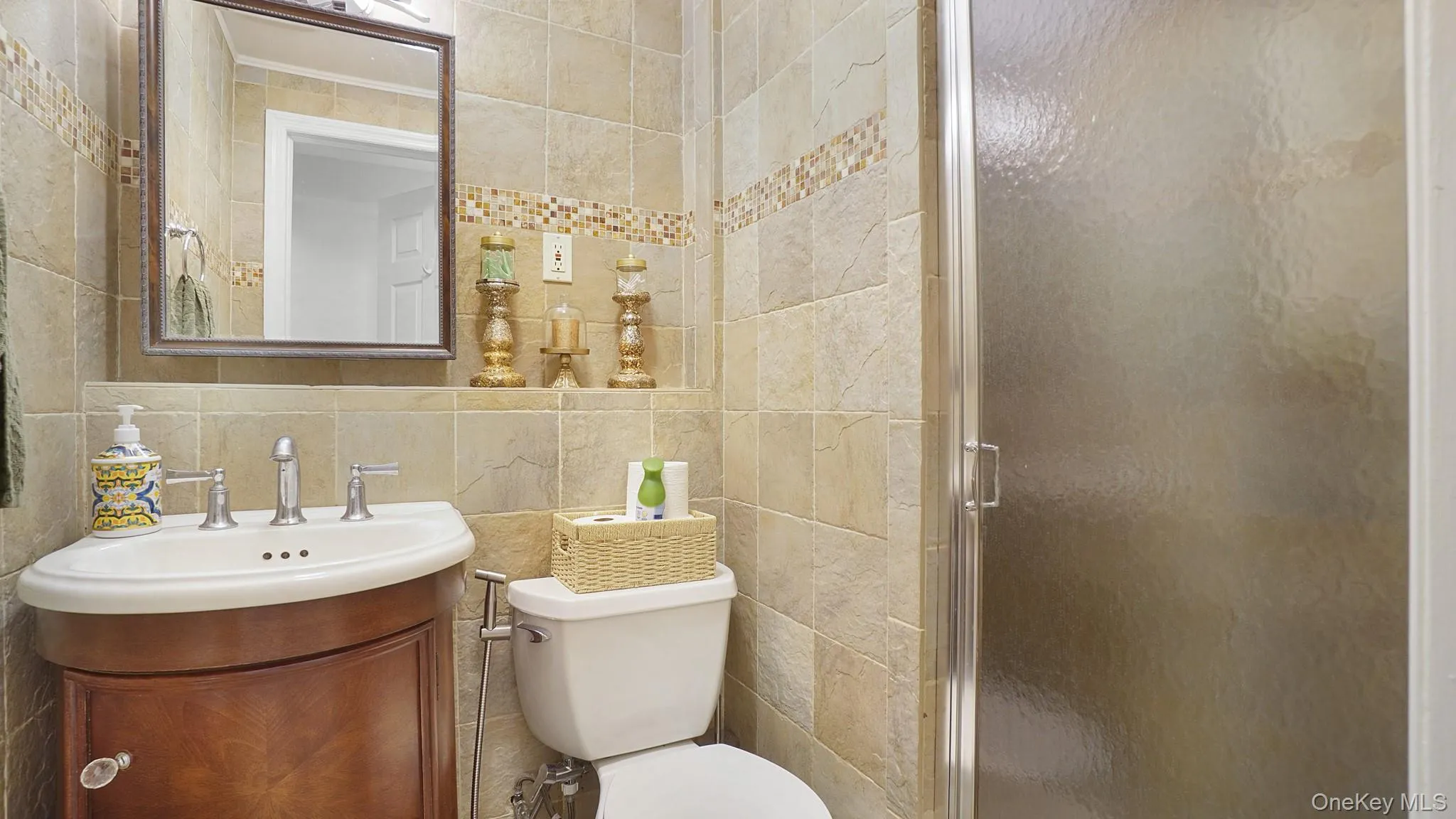 Bathroom featuring tile walls, a stall shower, vanity, and tasteful backsplash Bathroom featuring tile walls, a stall shower, vanity, and tasteful backsplash