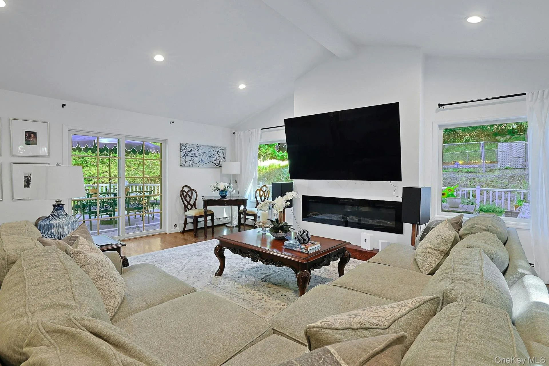 The electric fireplace adds beautiful ambiance and the slider opens to the wrap-around deck. The electric fireplace adds beautiful ambiance and the slider opens to the wrap-around deck.