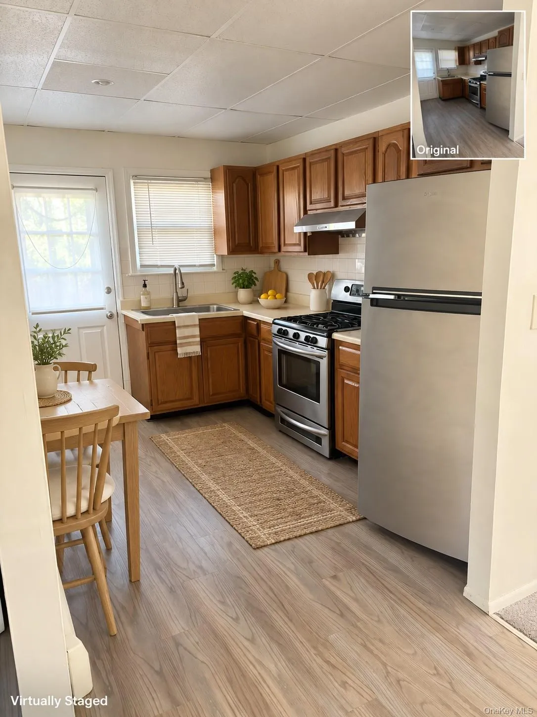 Wood-finish flooring, stainless steel appliances, wood cabinetry, white subway tile backsplash, and a white paneled door Wood-finish flooring, stainless steel appliances, wood cabinetry, white subway tile backsplash, and a white paneled door