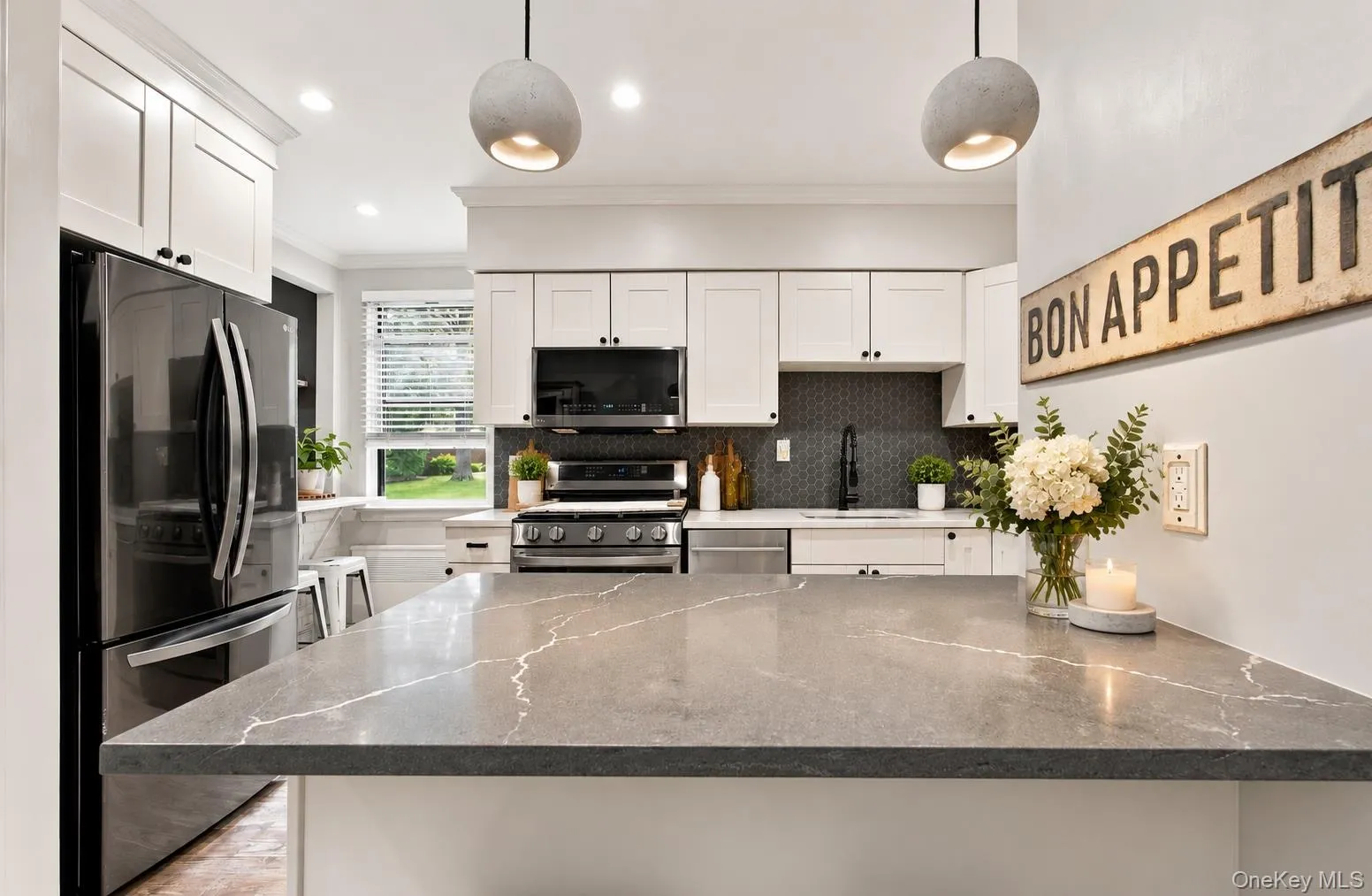 The alternate view showcases the kitchen's stainless steel appliances and bright, airy atmosphere. The alternate view showcases the kitchen's stainless steel appliances and bright, airy atmosphere.