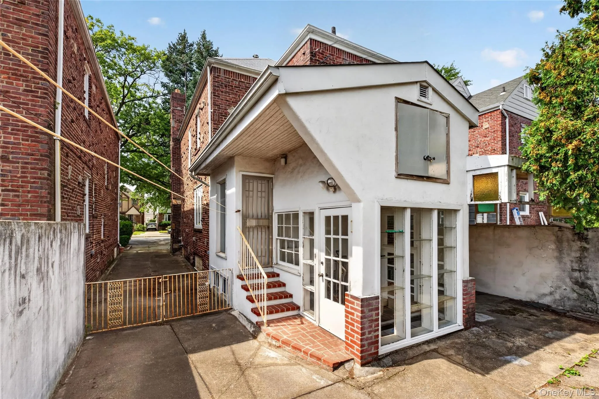 Contemporary brick and stucco exterior featuring a gabled roofline, multi-pane French doors with sidelights, and a raised brick entry stoop Contemporary brick and stucco exterior featuring a gabled roofline, multi-pane French doors with sidelights, and a raised brick entry stoop