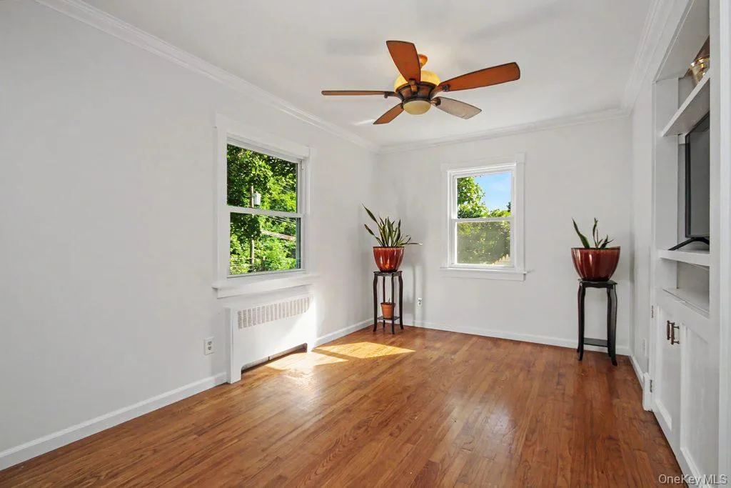 Living Room has ceiling fan with light, built in shelving and cabinetry Living Room has ceiling fan with light, built in shelving and cabinetry