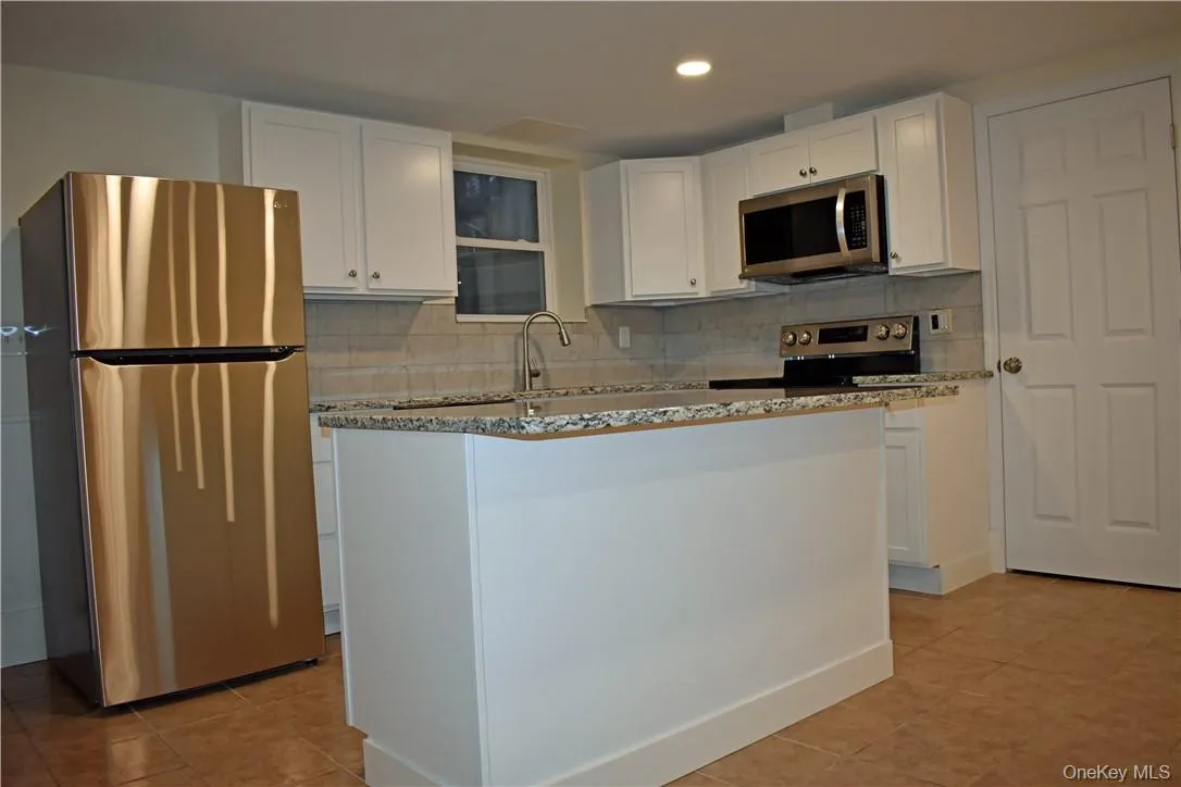 Stainless steel appliances, white cabinetry, granite countertops, tile backsplash, and recessed lighting Stainless steel appliances, white cabinetry, granite countertops, tile backsplash, and recessed lighting