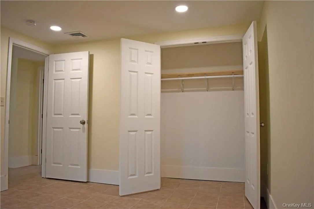 Recessed lighting illuminates neutral-toned walls and tile flooring Recessed lighting illuminates neutral-toned walls and tile flooring