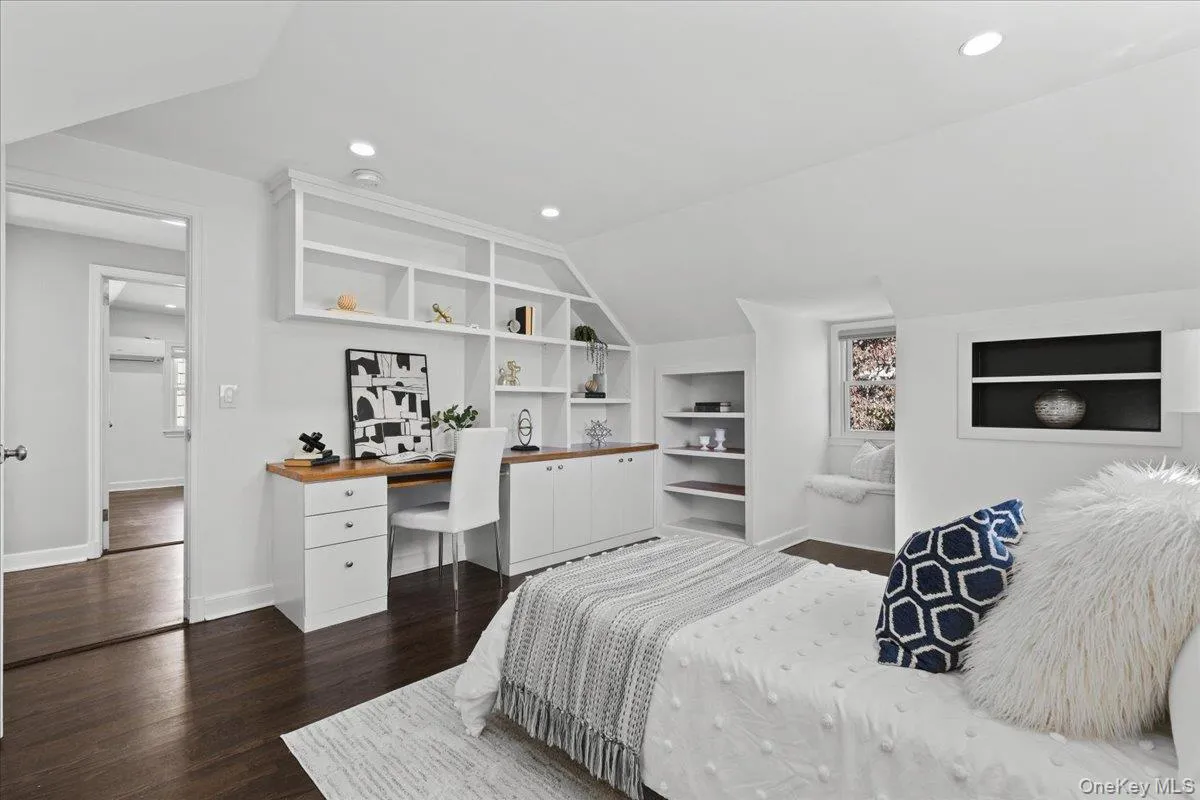 Upstairs bedroom with built-in desk and shelving and walk in closet Upstairs bedroom with built-in desk and shelving and walk in closet