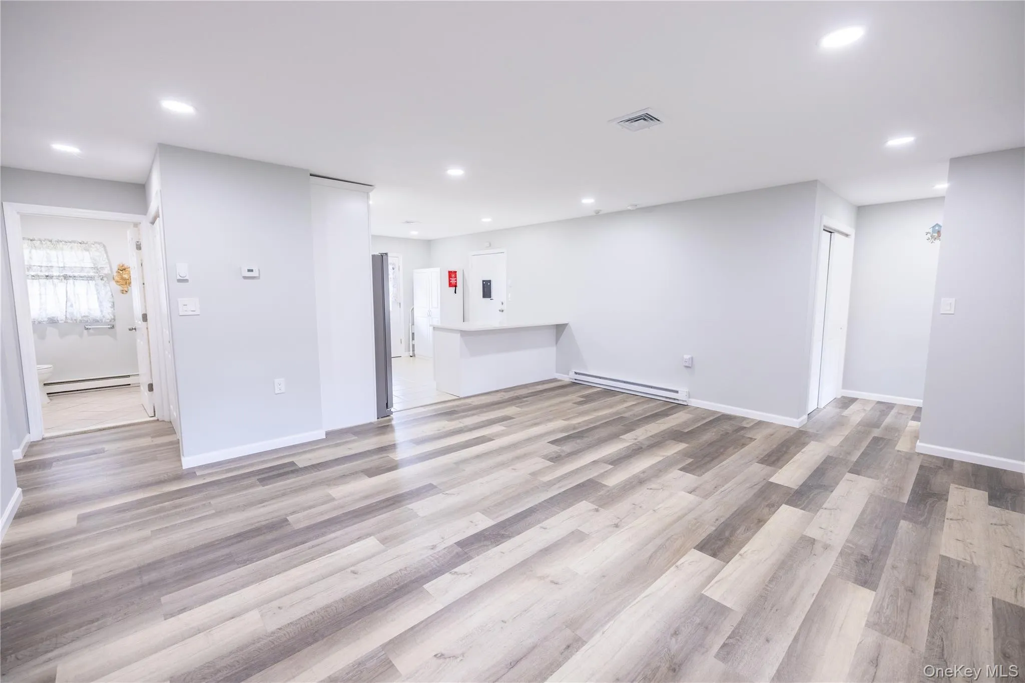 Spacious interior featuring wood-finish flooring, recessed lighting, and light-toned walls Spacious interior featuring wood-finish flooring, recessed lighting, and light-toned walls