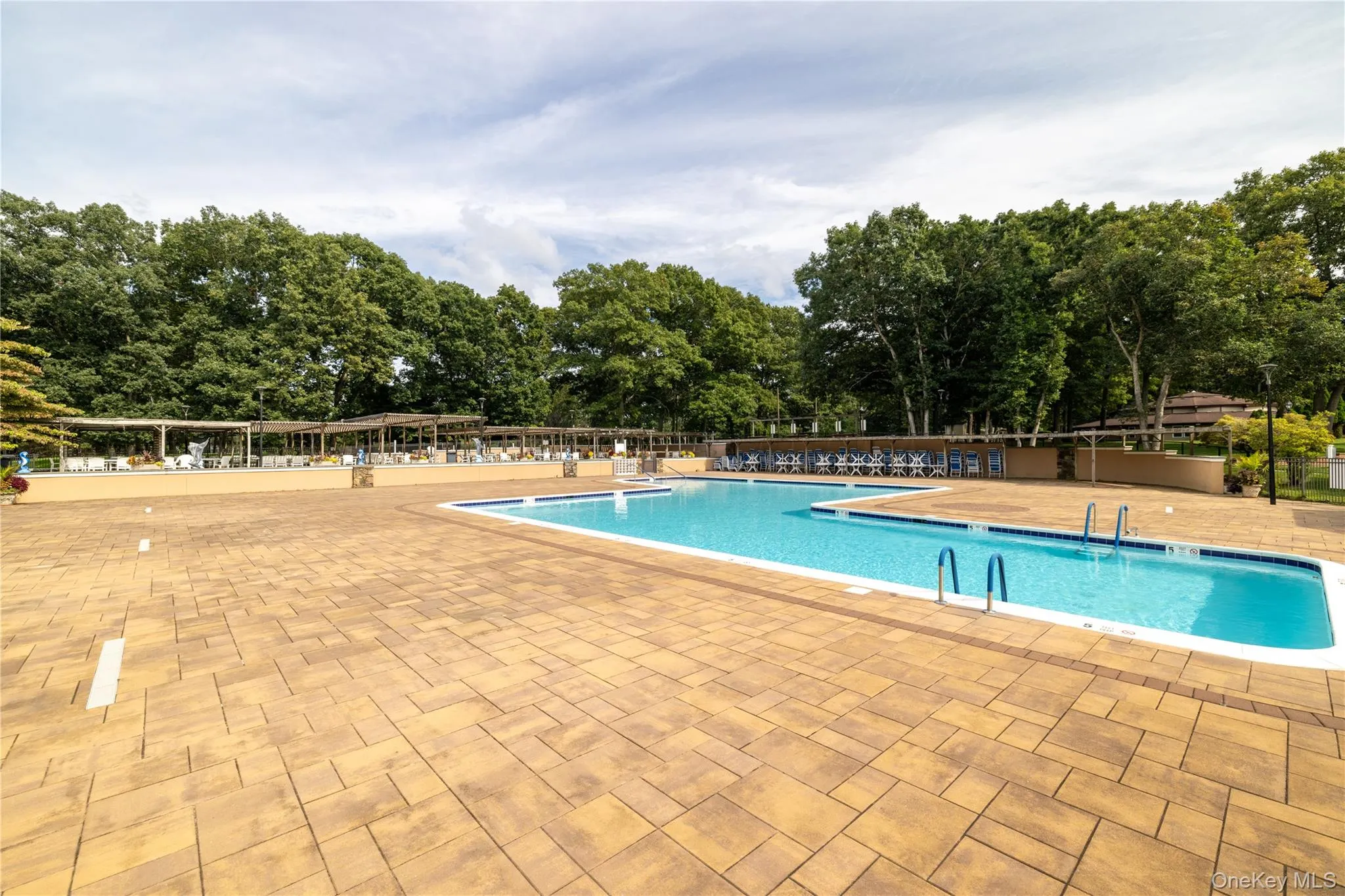 Expansive paver patio surrounding a large community swimming pool Expansive paver patio surrounding a large community swimming pool