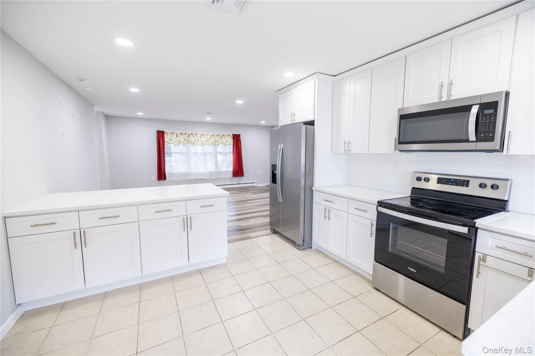 Modern kitchen featuring white cabinetry, stainless steel appliances, recessed lighting, and tile flooring Modern kitchen featuring white cabinetry, stainless steel appliances, recessed lighting, and tile flooring