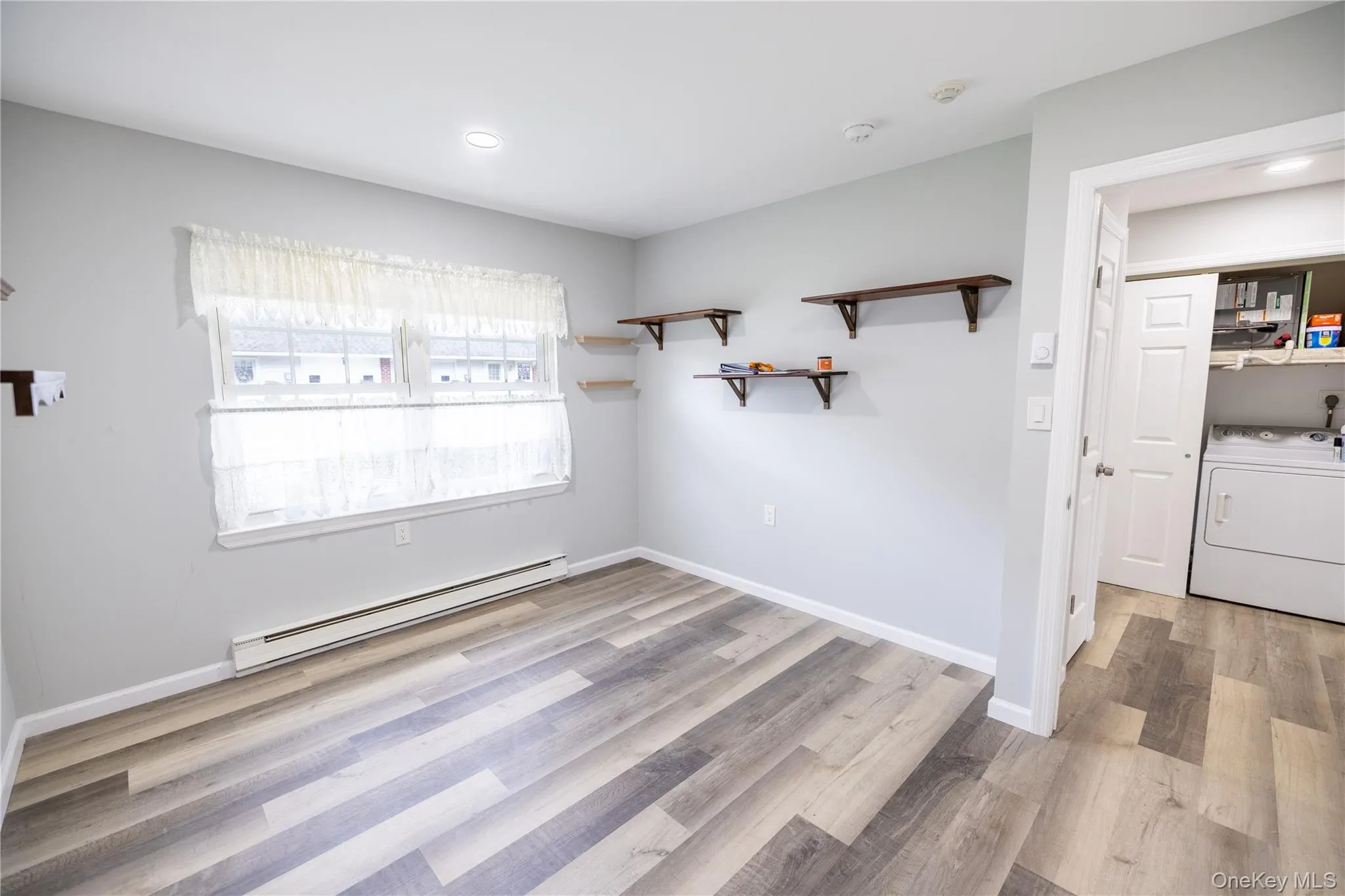 Wood-finish flooring throughout, recessed lighting, and a window with natural light Wood-finish flooring throughout, recessed lighting, and a window with natural light