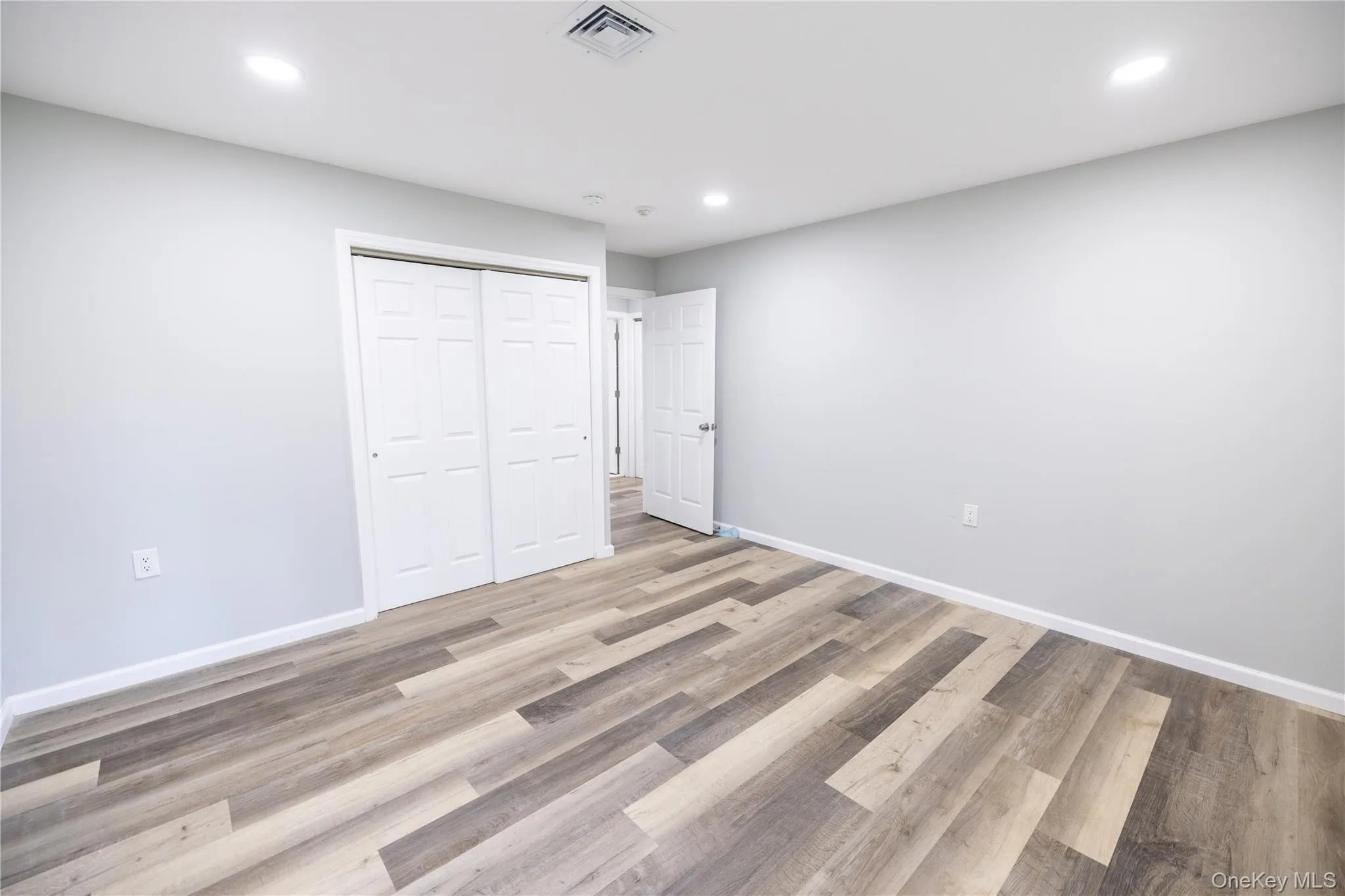 Recessed lighting, wood-finish flooring, white paneled doors, and light neutral wall paint Recessed lighting, wood-finish flooring, white paneled doors, and light neutral wall paint