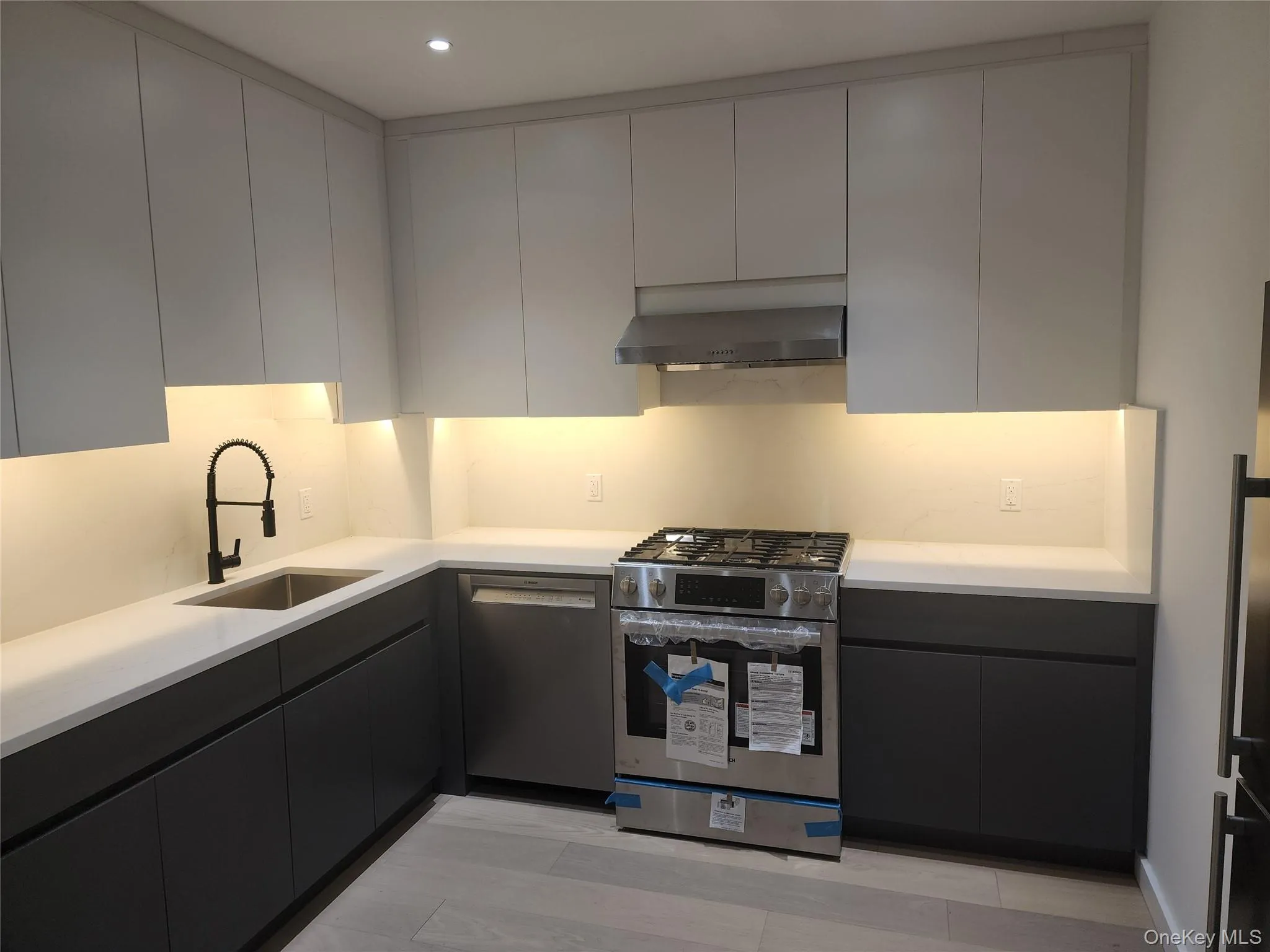 Modern kitchen featuring white upper cabinetry and dark lower cabinetry Modern kitchen featuring white upper cabinetry and dark lower cabinetry