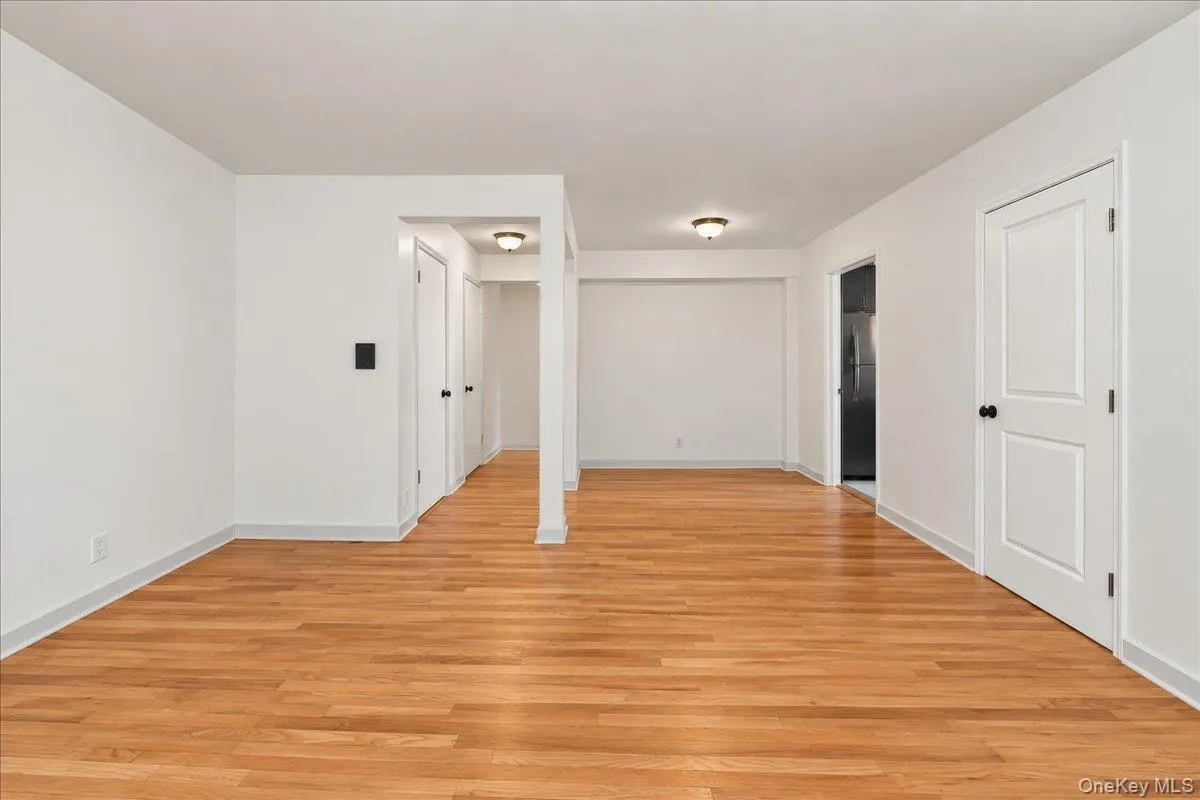 Wood-finish flooring throughout, white paneled doors, and recessed ceiling lights Wood-finish flooring throughout, white paneled doors, and recessed ceiling lights