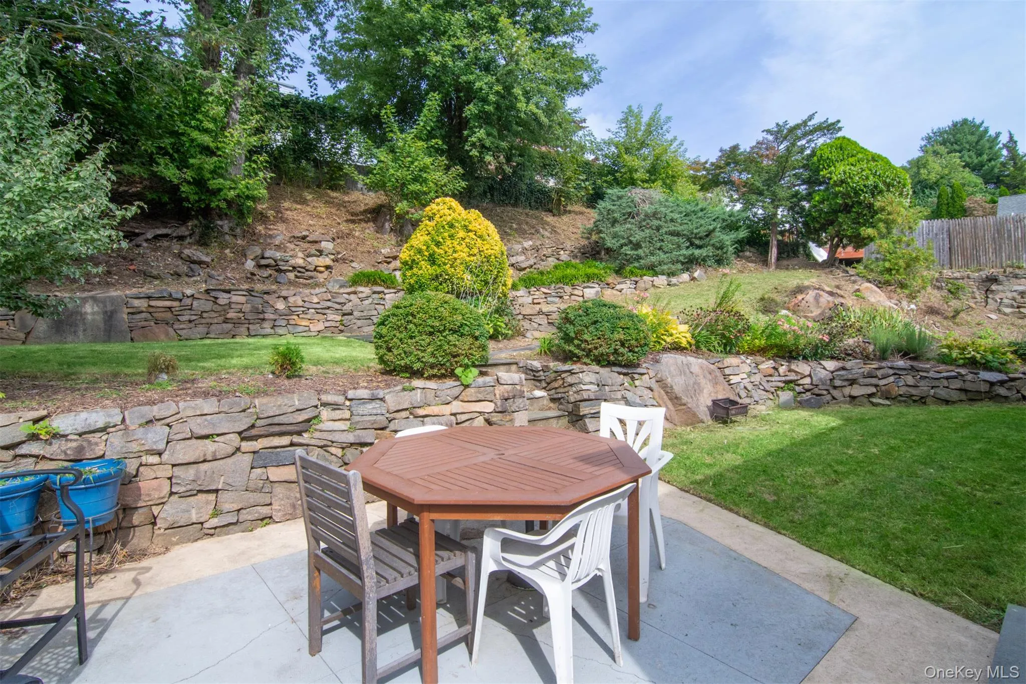 A beautiful backyard sanctuary featuring a private patio and tiered gardens. A beautiful backyard sanctuary featuring a private patio and tiered gardens.