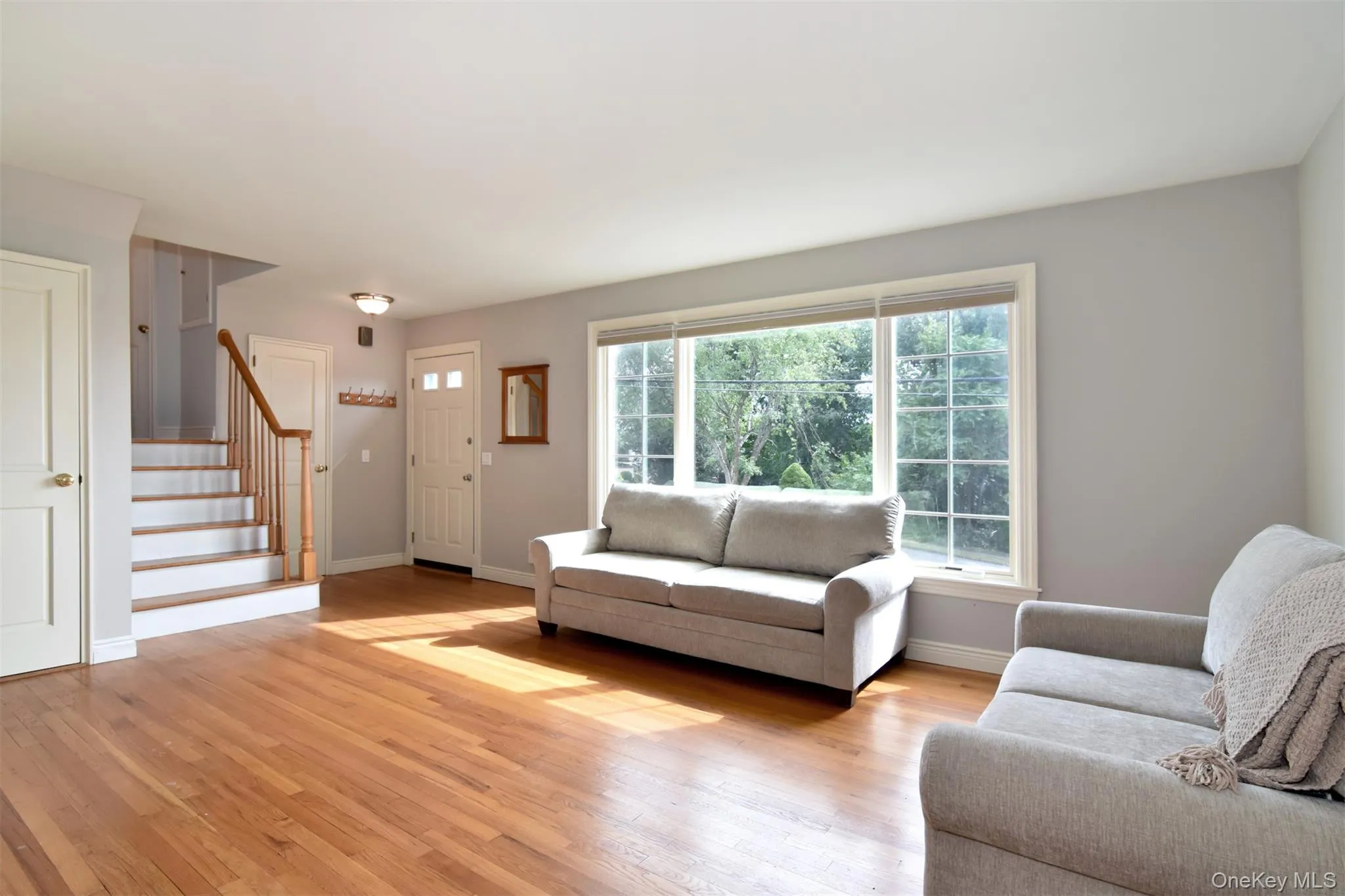 A sun-drenched entry and living room welcome you in, complemented by gleaming hardwood floors throughout. A sun-drenched entry and living room welcome you in, complemented by gleaming hardwood floors throughout.