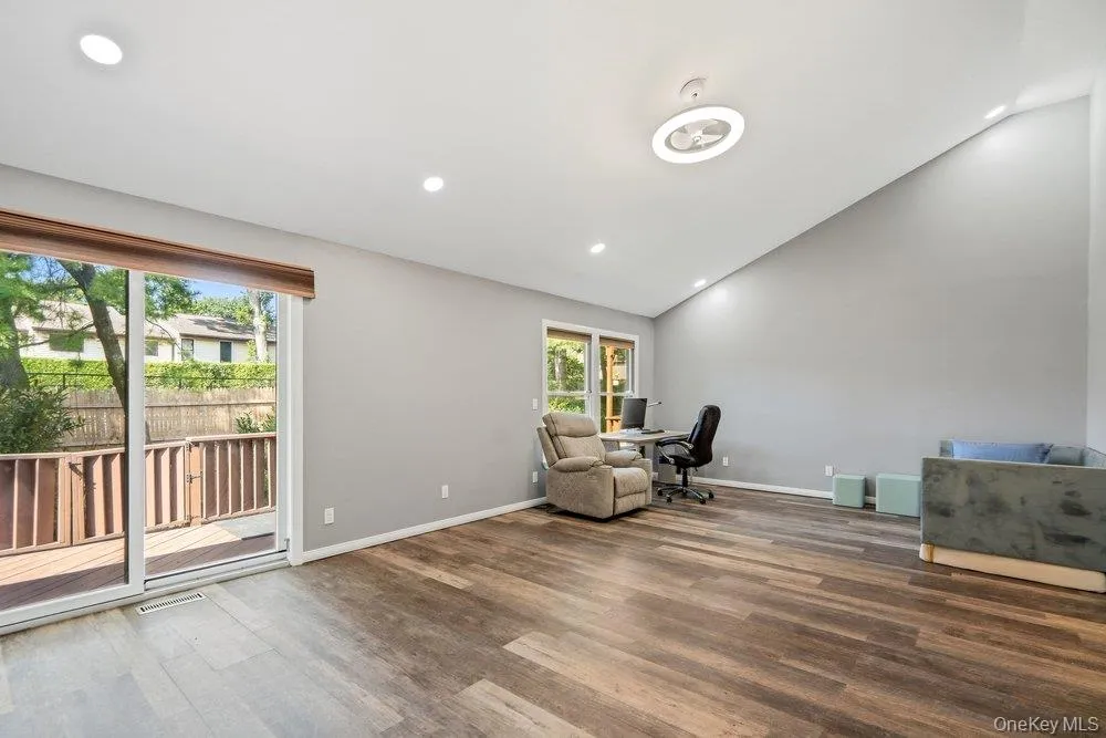 Vaulted ceiling, recessed lighting, wood-finish flooring, sliding glass door, and a built-in deck Vaulted ceiling, recessed lighting, wood-finish flooring, sliding glass door, and a built-in deck