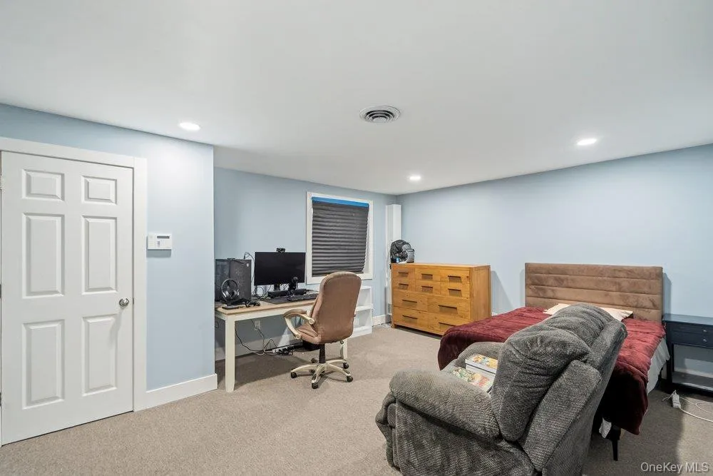 Recessed lighting, light blue wall paint, window with blinds, six-panel interior door, and carpeted flooring Recessed lighting, light blue wall paint, window with blinds, six-panel interior door, and carpeted flooring