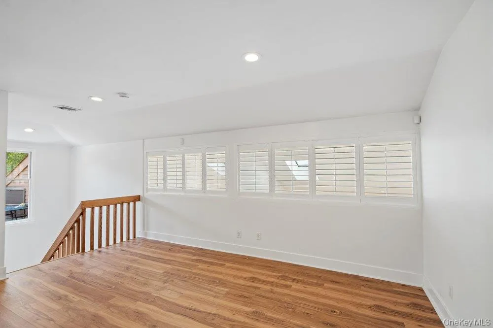 Wood-finish flooring, white walls, and recessed lighting Wood-finish flooring, white walls, and recessed lighting