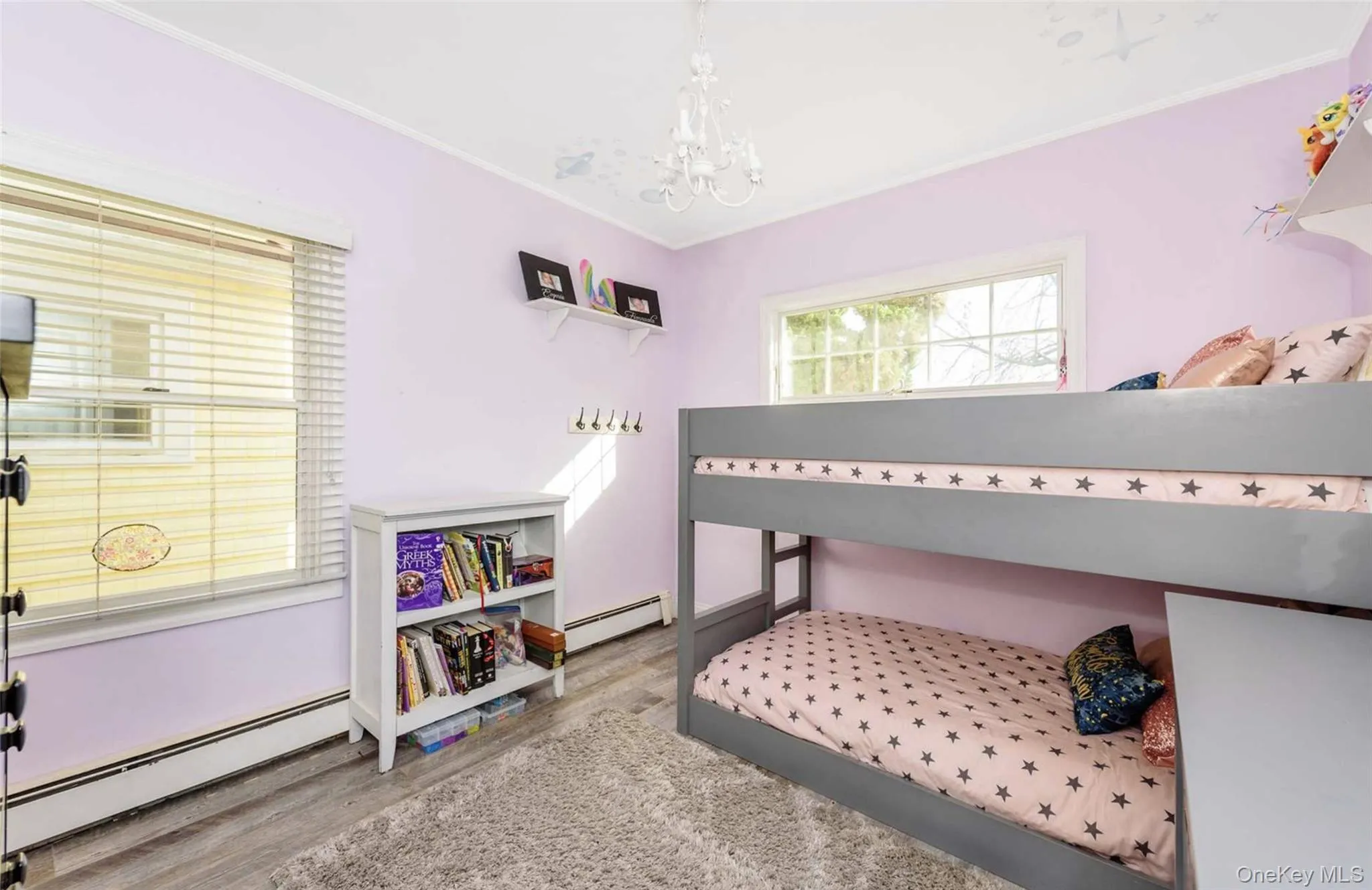 Bedroom with wood-type flooring, crown molding, a baseboard heating unit, and a notable chandelier Bedroom with wood-type flooring, crown molding, a baseboard heating unit, and a notable chandelier