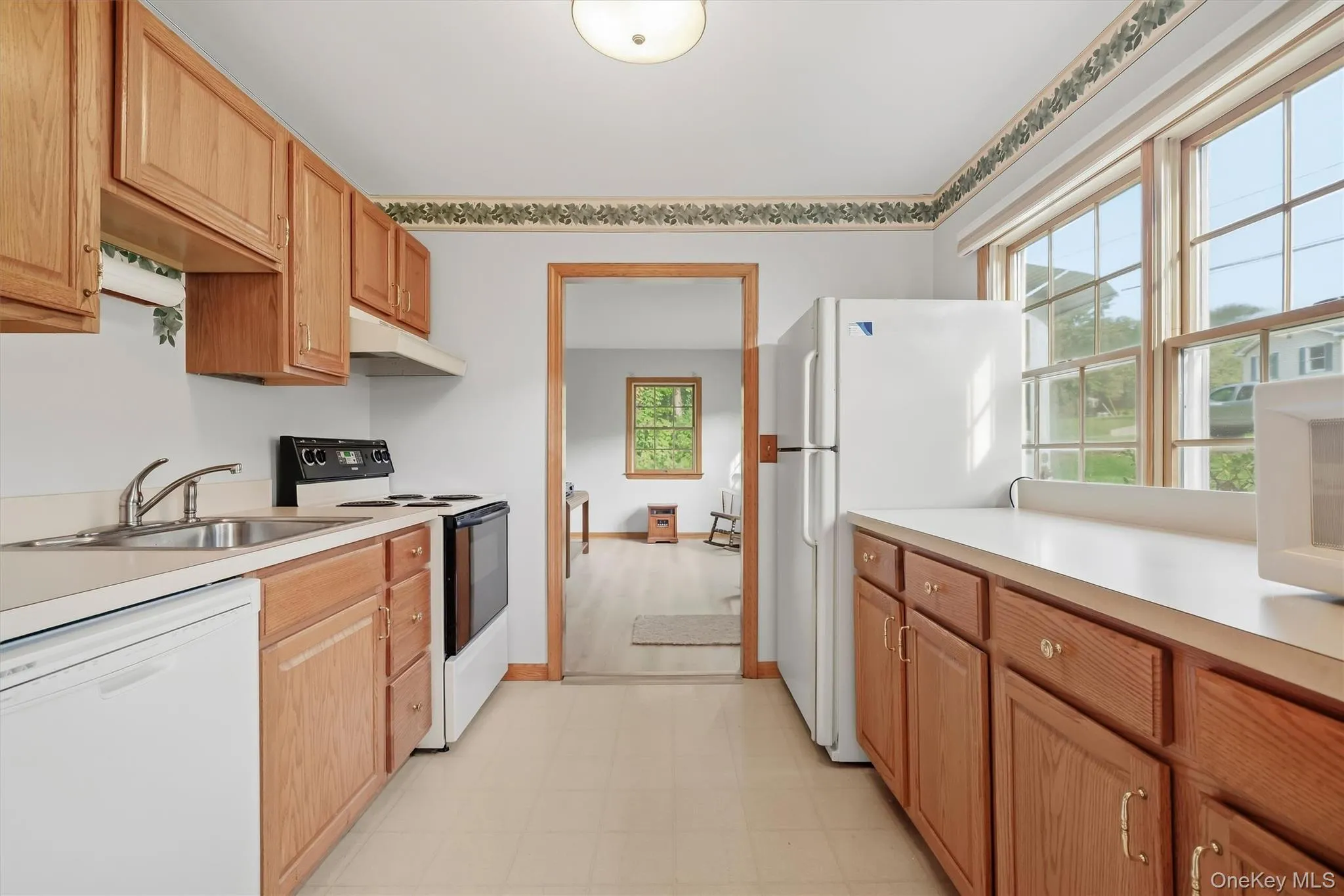 Kitchen featuring wood cabinetry, a stainless steel sink, and ample natural light from the double window Kitchen featuring wood cabinetry, a stainless steel sink, and ample natural light from the double window