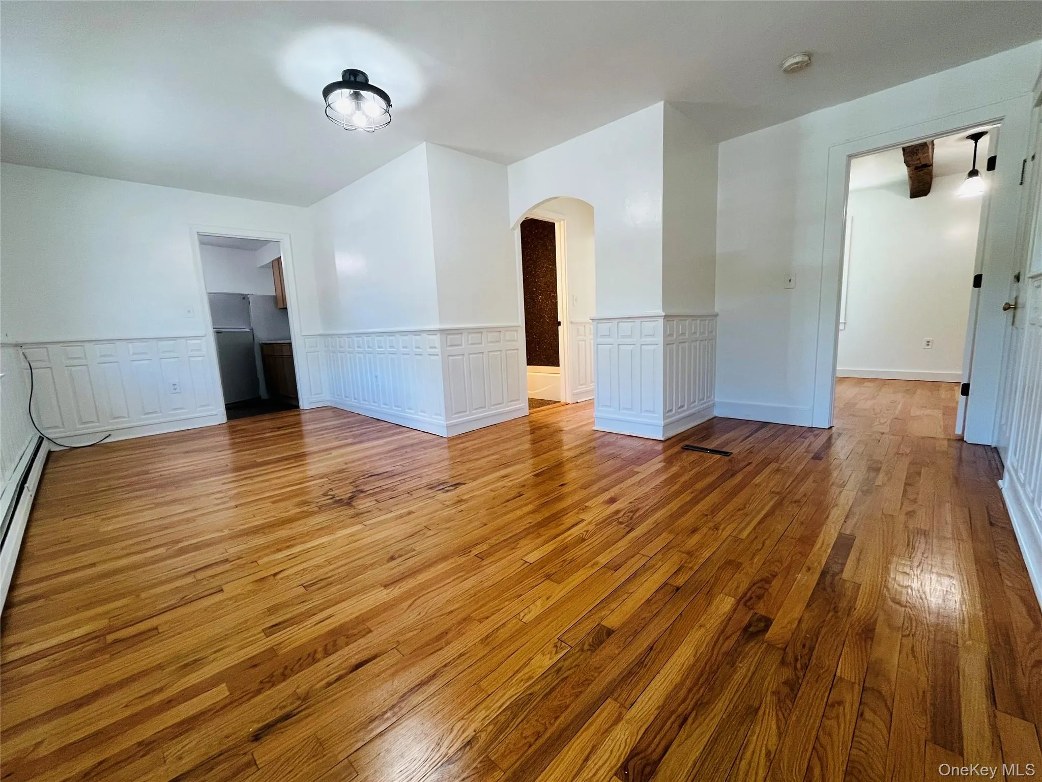 Large living room with hardwood floors and wainscoting throughout. Closet not shown. Large living room with hardwood floors and wainscoting throughout. Closet not shown.