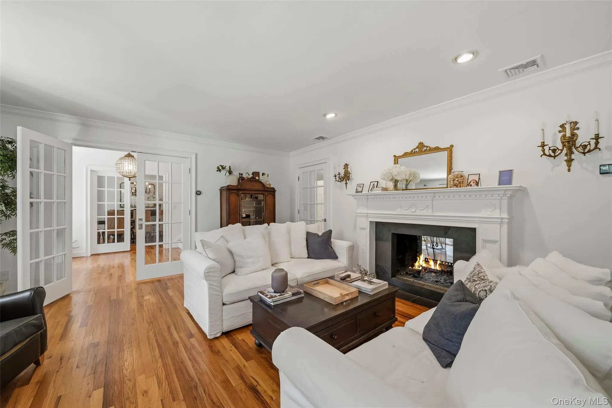 Living room with beautiful wood burning double sided fireplace and french doors Living room with beautiful wood burning double sided fireplace and french doors