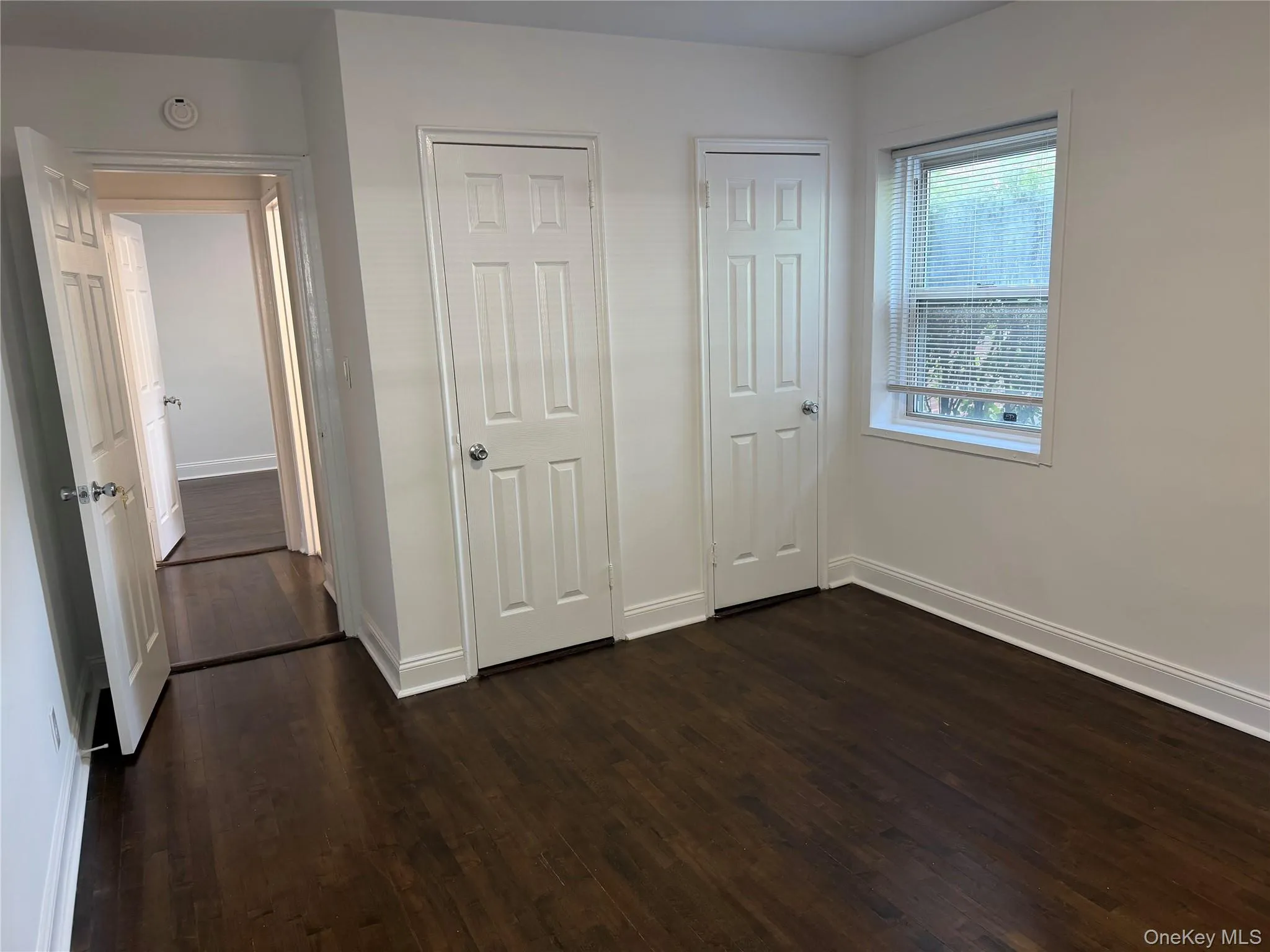 Twin closets with new doors in primary bedroom. Twin closets with new doors in primary bedroom.