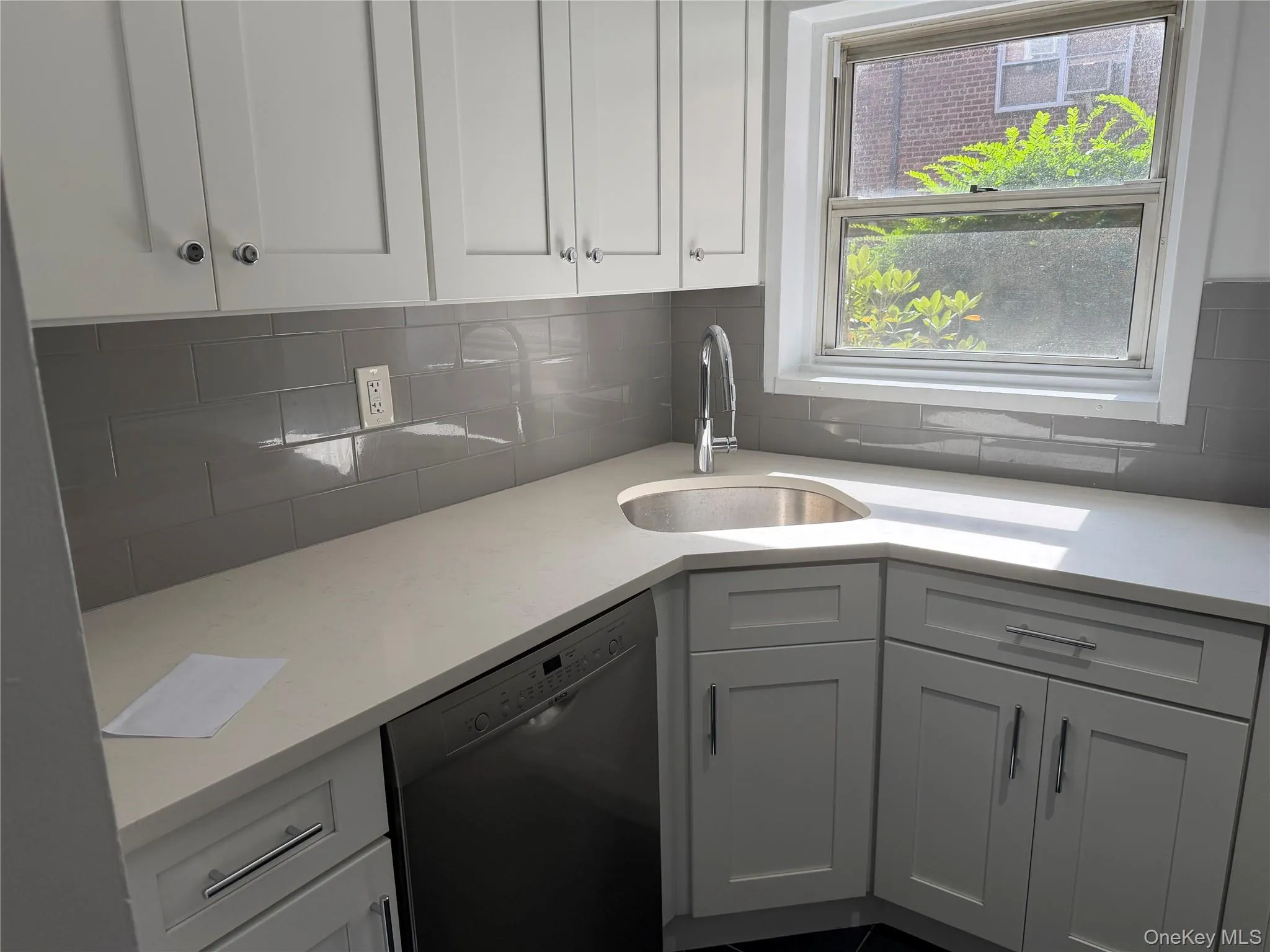 Sunny kitchen window, with tile backsplash, dishwasher and lots of cabinets. Sunny kitchen window, with tile backsplash, dishwasher and lots of cabinets.