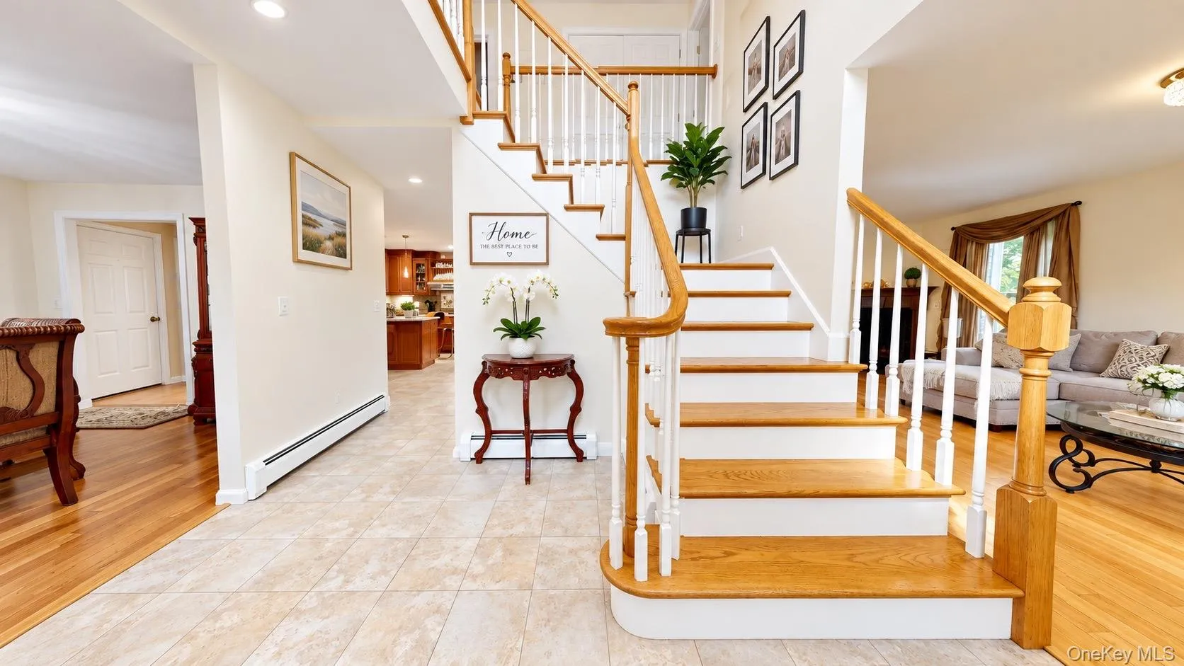 Grand entryway featuring tile flooring, a hardwood staircase with white risers, a wood handrail, and recessed lighting Grand entryway featuring tile flooring, a hardwood staircase with white risers, a wood handrail, and recessed lighting