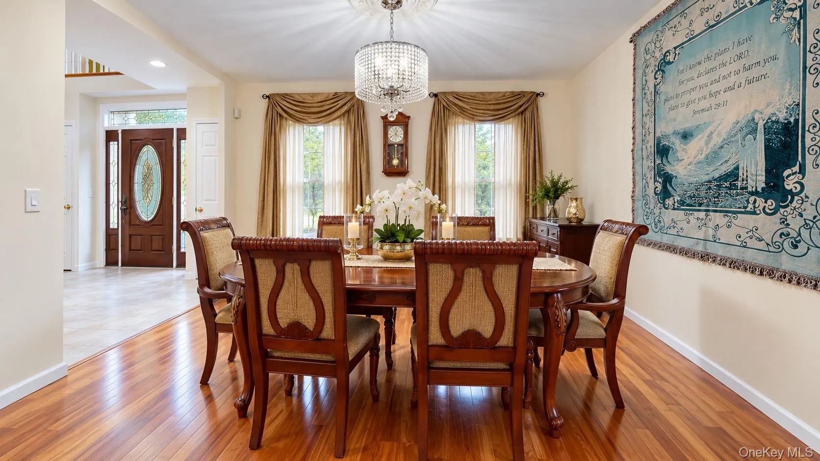 Warm wood-finish flooring with a crystal chandelier, recessed lighting, and a decorative front entry door with leaded glass Warm wood-finish flooring with a crystal chandelier, recessed lighting, and a decorative front entry door with leaded glass