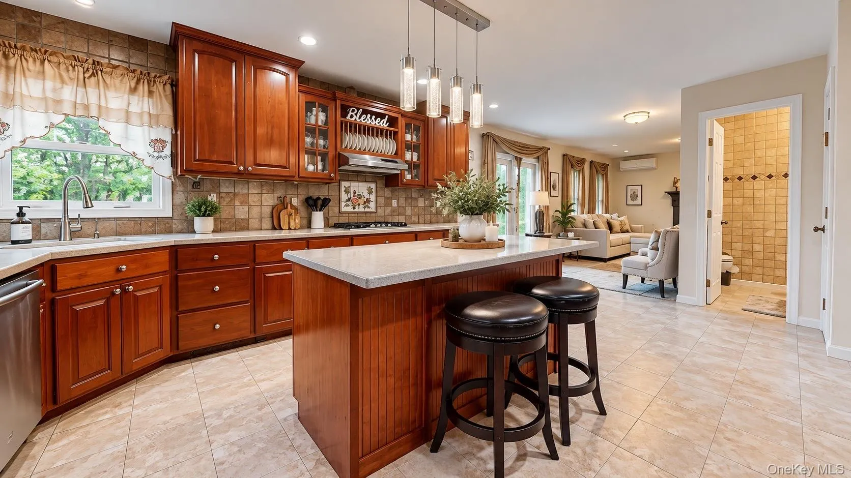 Cherry wood cabinetry, light-toned tiled flooring, center island with seating, stainless steel appliances, and a tiled backsplash Cherry wood cabinetry, light-toned tiled flooring, center island with seating, stainless steel appliances, and a tiled backsplash