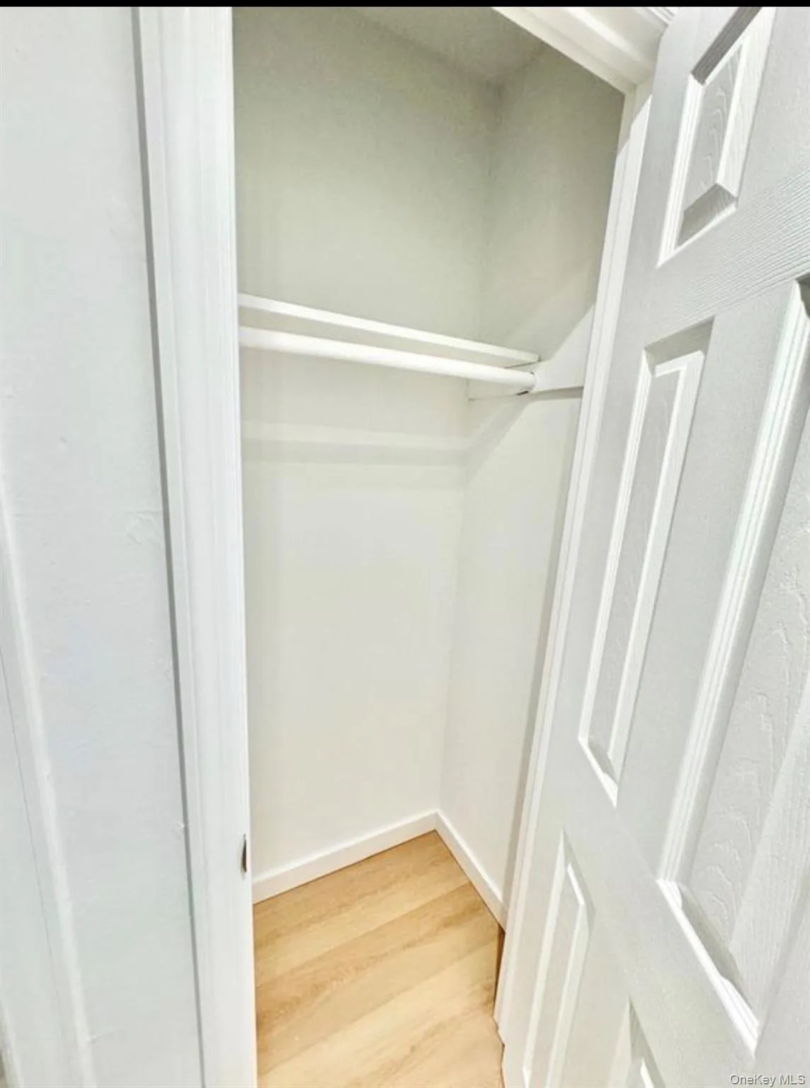 Built-in closet with dual hanging rods, wood-finish flooring, and crisp white trim Built-in closet with dual hanging rods, wood-finish flooring, and crisp white trim